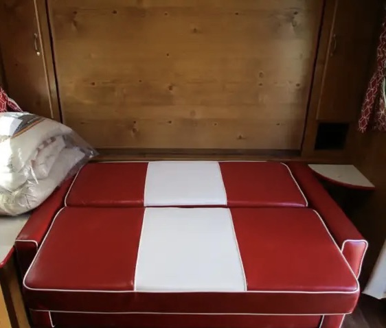 Cozy RV rental interior features a red and white dinette with bench seating, convertible to a comfortable bed.. Gulf Stream Vintage Cruiser 2021