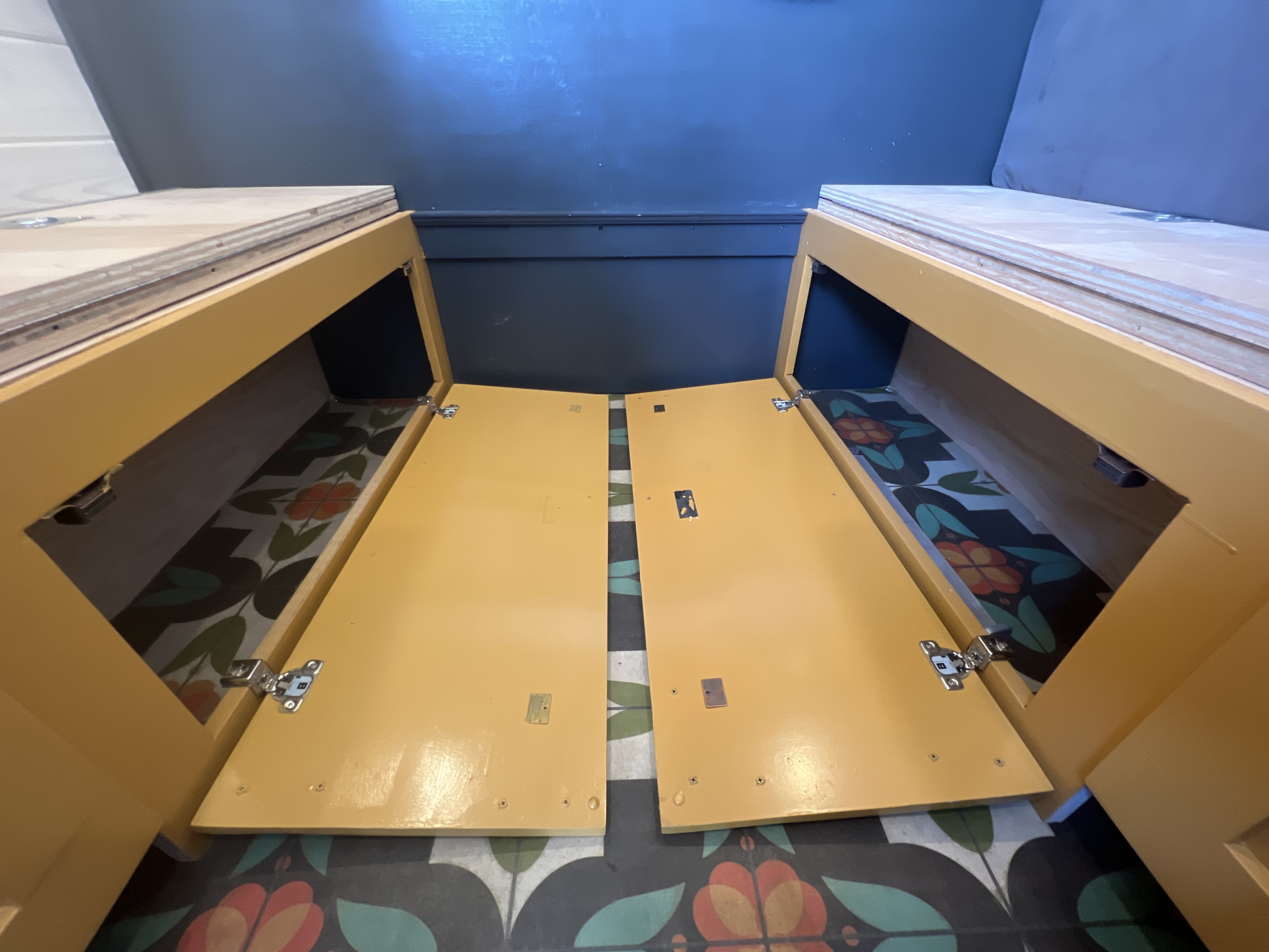 RV rental custom build: Open yellow storage benches with a colorful patterned floor inside, ideal for maximizing space.. Mercedes-Benz Sprinter RV Motorhome Campervan 2022