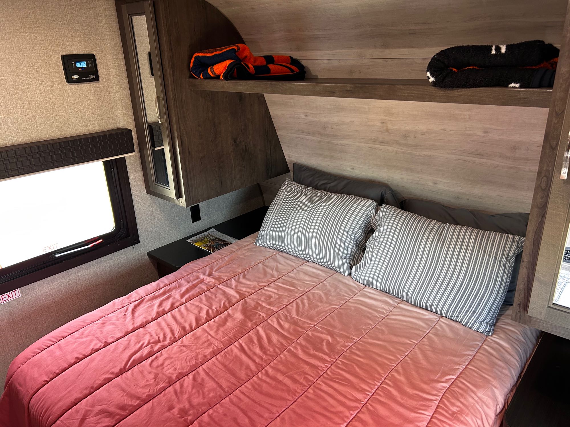 Cozy RV rental bedroom with a bed, window, solar controller, & overhead storage. Perfect for mobile travel.. Jayco Jay Flight SLX 2021