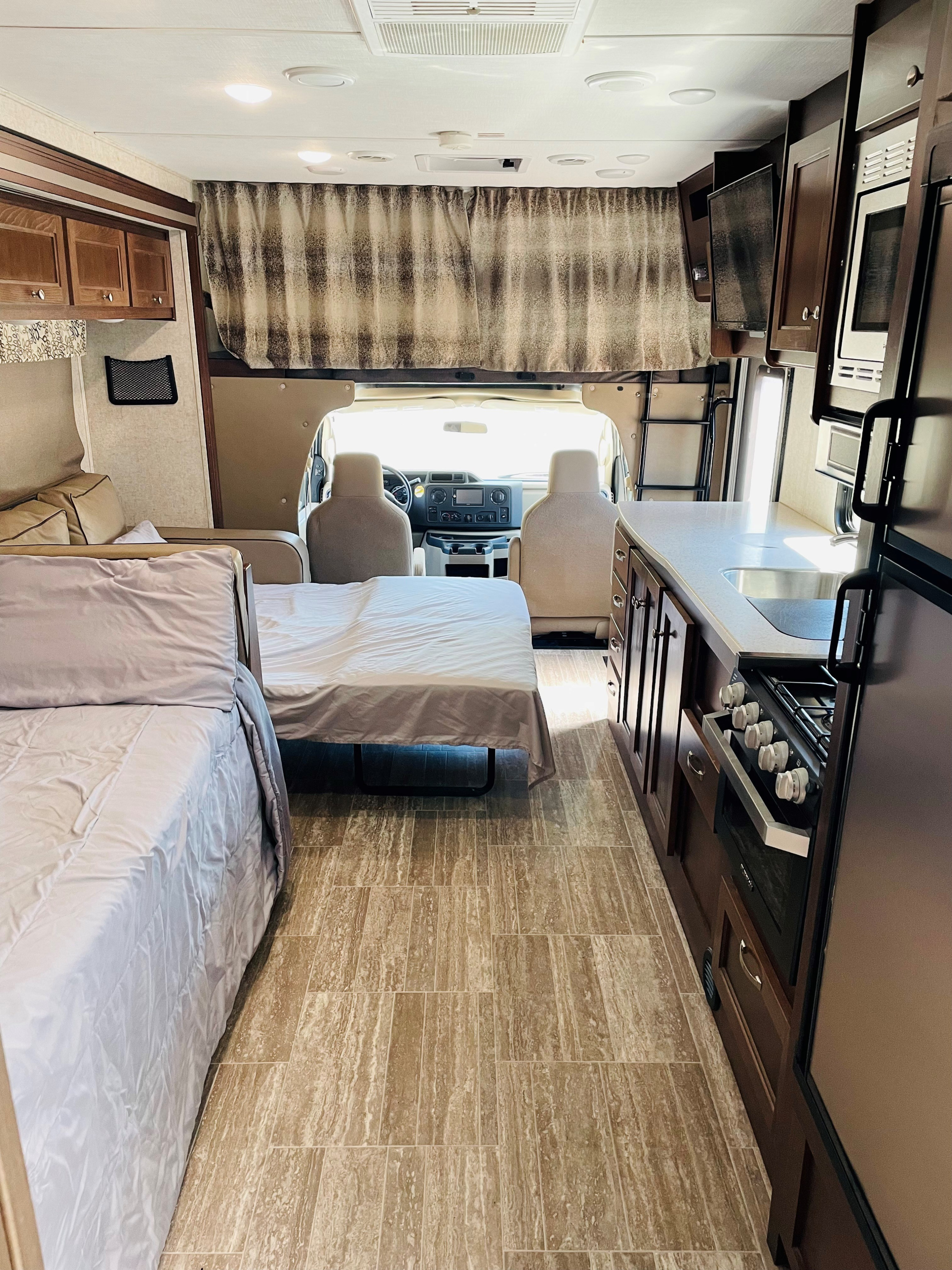Cozy RV rental interior showing a bed, galley kitchen, and front cab for comfortable mobile adventures.. Forester Forester Motorhome 2020