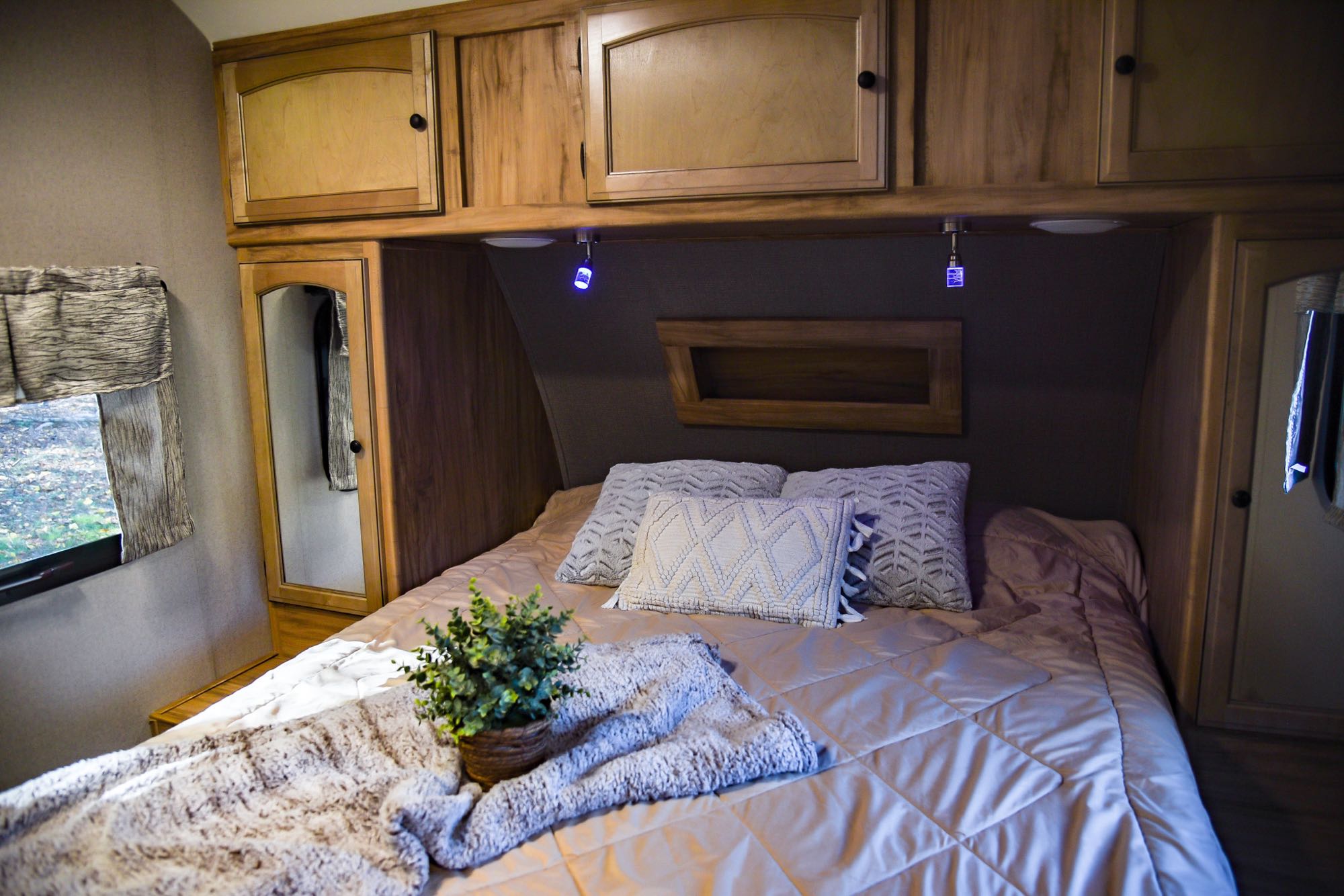 Comfortable RV rental bedroom with ample overhead storage, soft bedding, and convenient reading lights for your journey.. Coachmen Freedom Express 2018