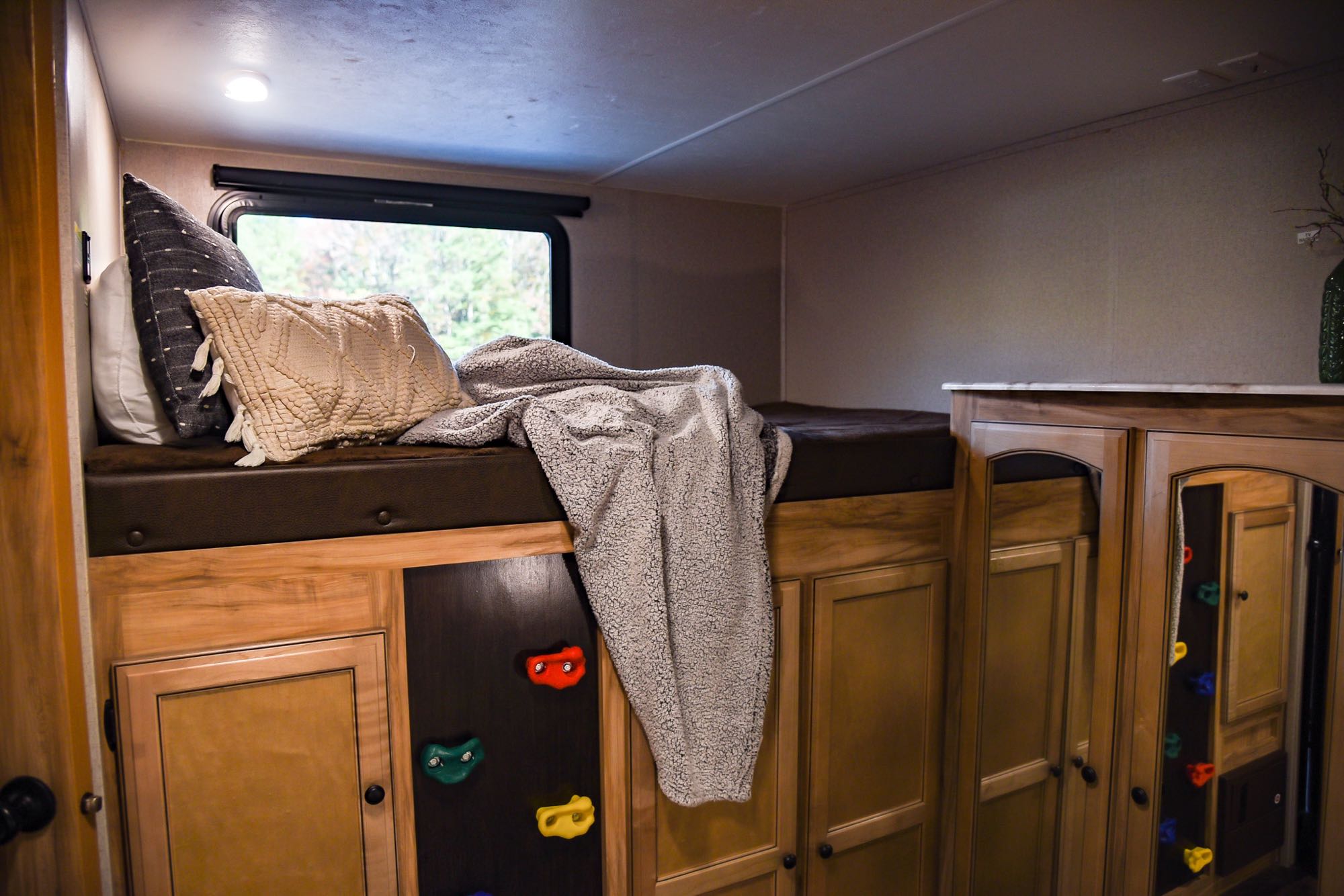 This RV rental offers a cozy bunk bed with pillows, under-bed storage cabinets, and colorful climbing holds for access.. Coachmen Freedom Express 2018