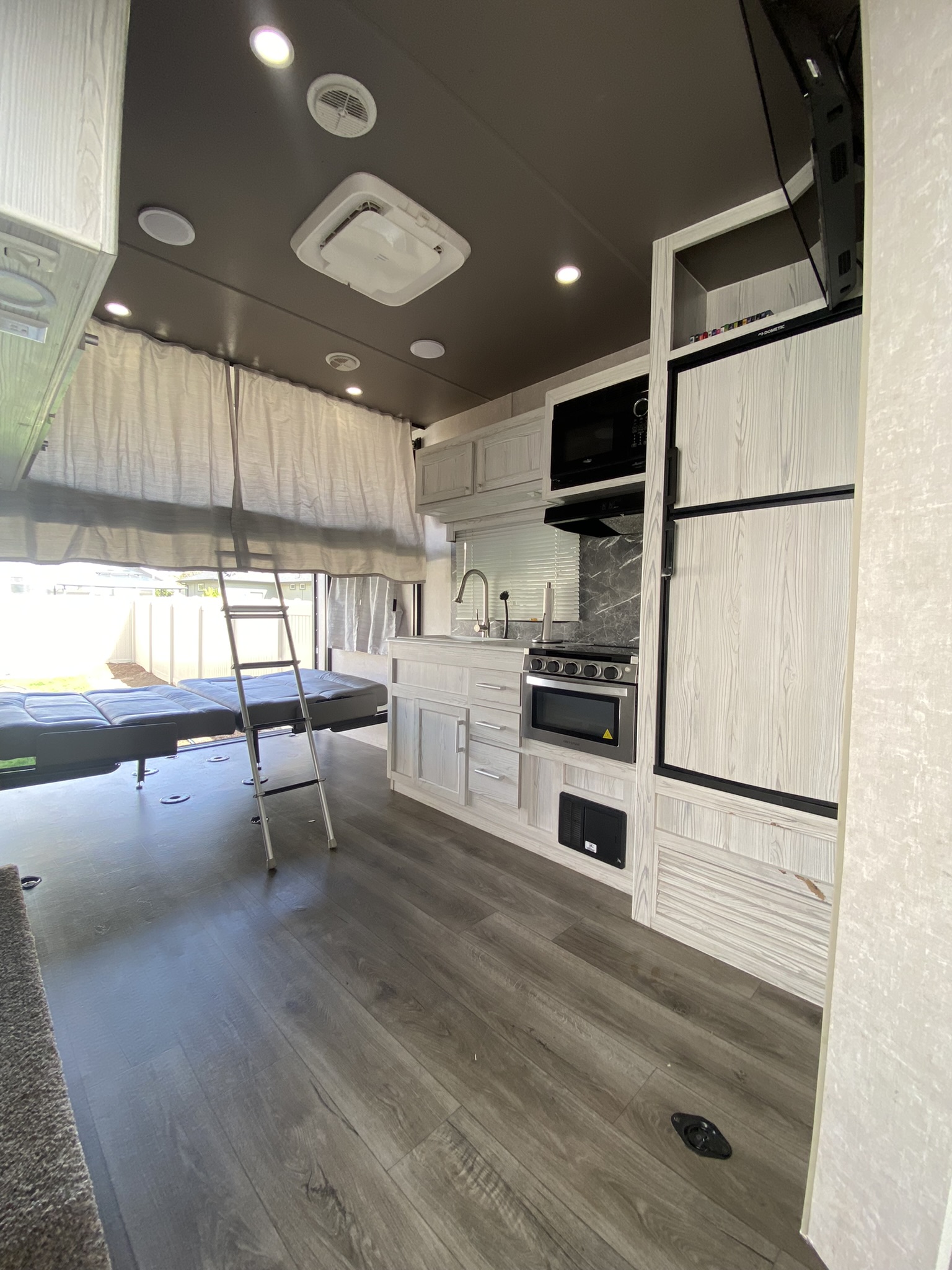 Modern RV rental interior: kitchenette, loft bed w/ ladder, & versatile living space. Perfect for trips!. Eclipse Recreational Vehicles Attitude 2021