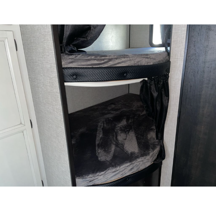 RV rental interior shows two bunk beds with dark grey bedding, privacy curtains, and textured walls.. JAYCO JAY FLIGHT 2023