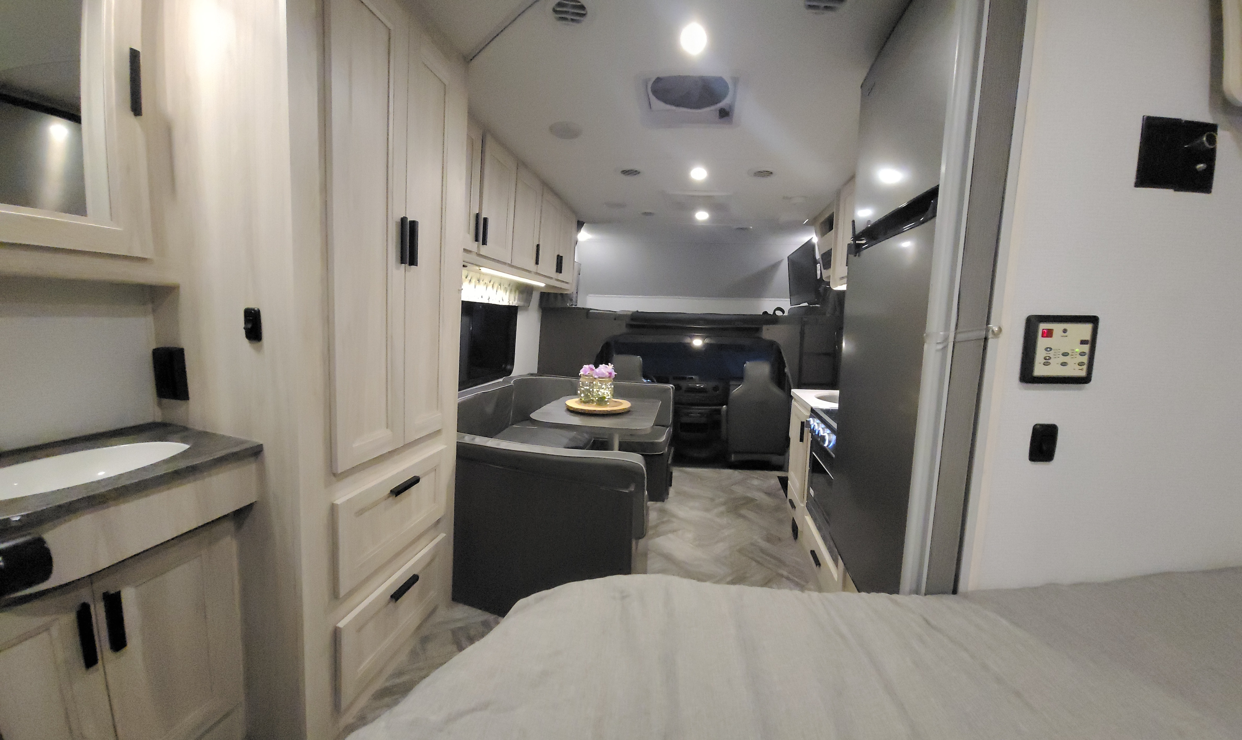Well-equipped RV rental interior with compact kitchen, dining, bathroom vanity, and bedroom.. Forest River Sunseeker LE 2022