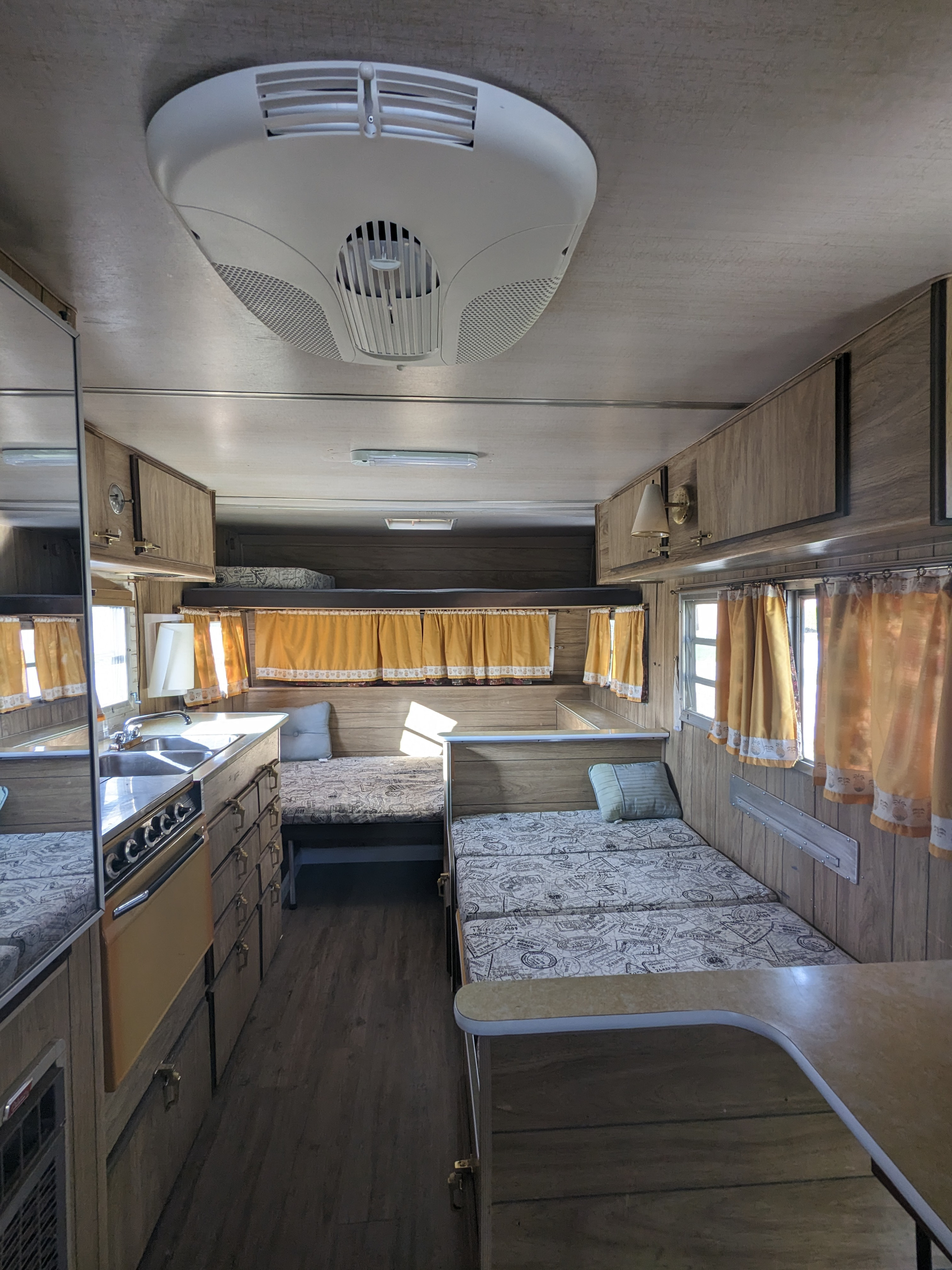 Step inside this charming rv rental. Features a galley kitchen, multiple beds, and classic wood paneling.. Aristocrat Land liner 1972