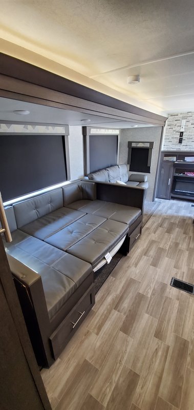 Modern RV rental interior showcasing a gray sofa bed with storage, wood-look floor, and cozy lighting.. Forest River Salem 2020