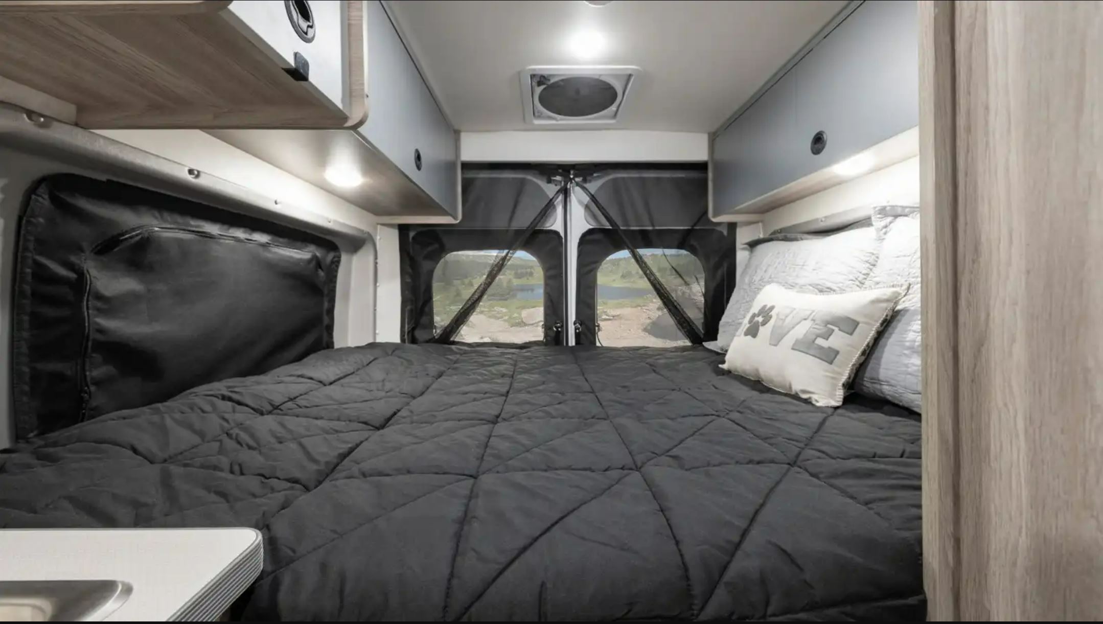 RV rental: This cozy camper van features a comfy bed, overhead storage, and mesh-covered rear doors with scenic views.. Winnebago Solis 2023