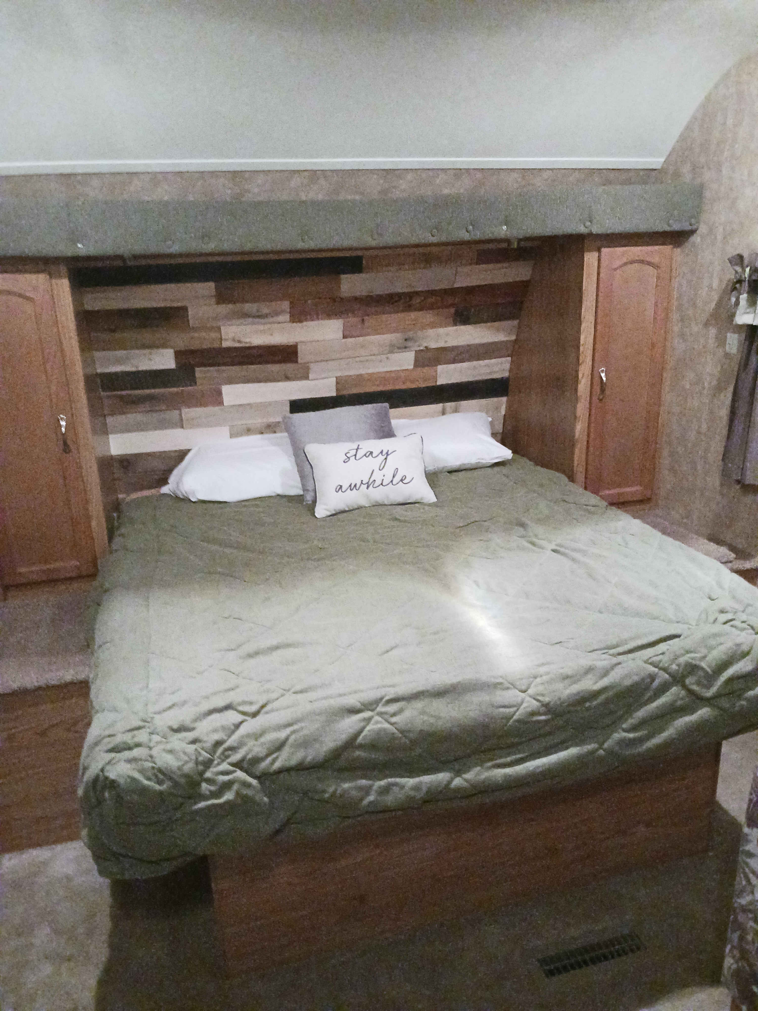 Cozy RV rental bedroom: comfy bed, wood-plank headboard, built-in storage units for travelers.. Timberland Wedge 2008