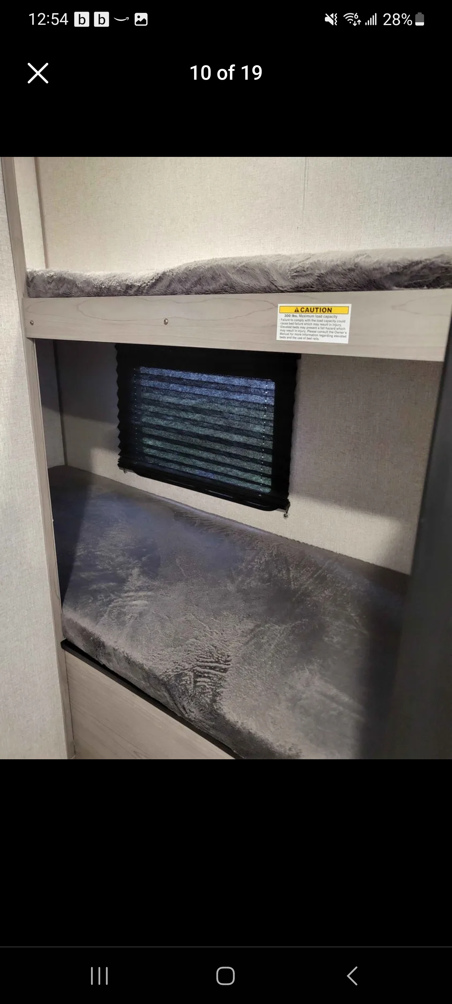 Spacious RV rental bunk beds with window and safety warning. Ideal for family adventures.. Dutchmen Coleman Lantern LT 2022