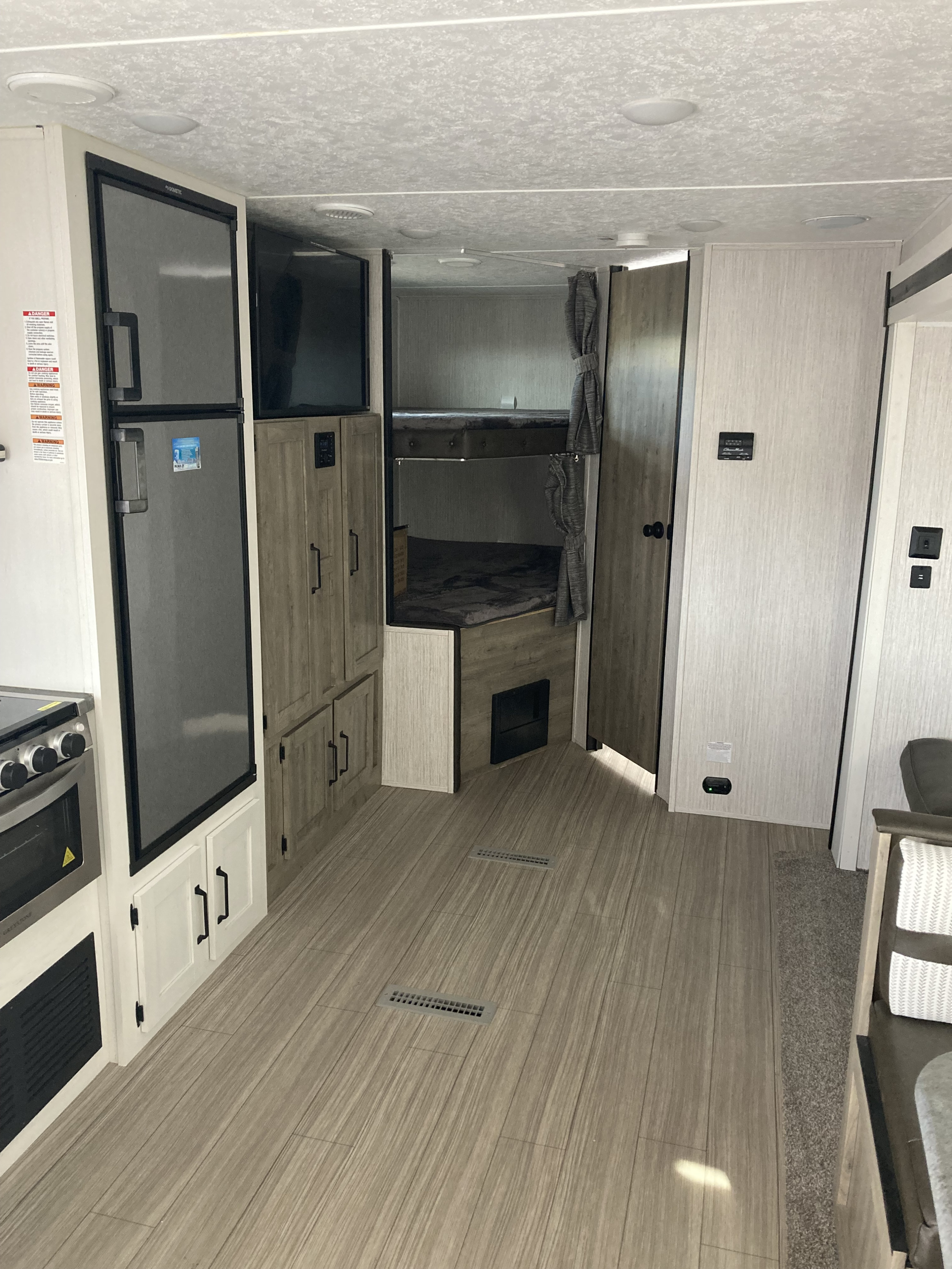 Spacious RV rental interior with kitchen, bunks, and wood-look flooring. Perfect for your next camper adventure.. Palomino Puma XLE 2022