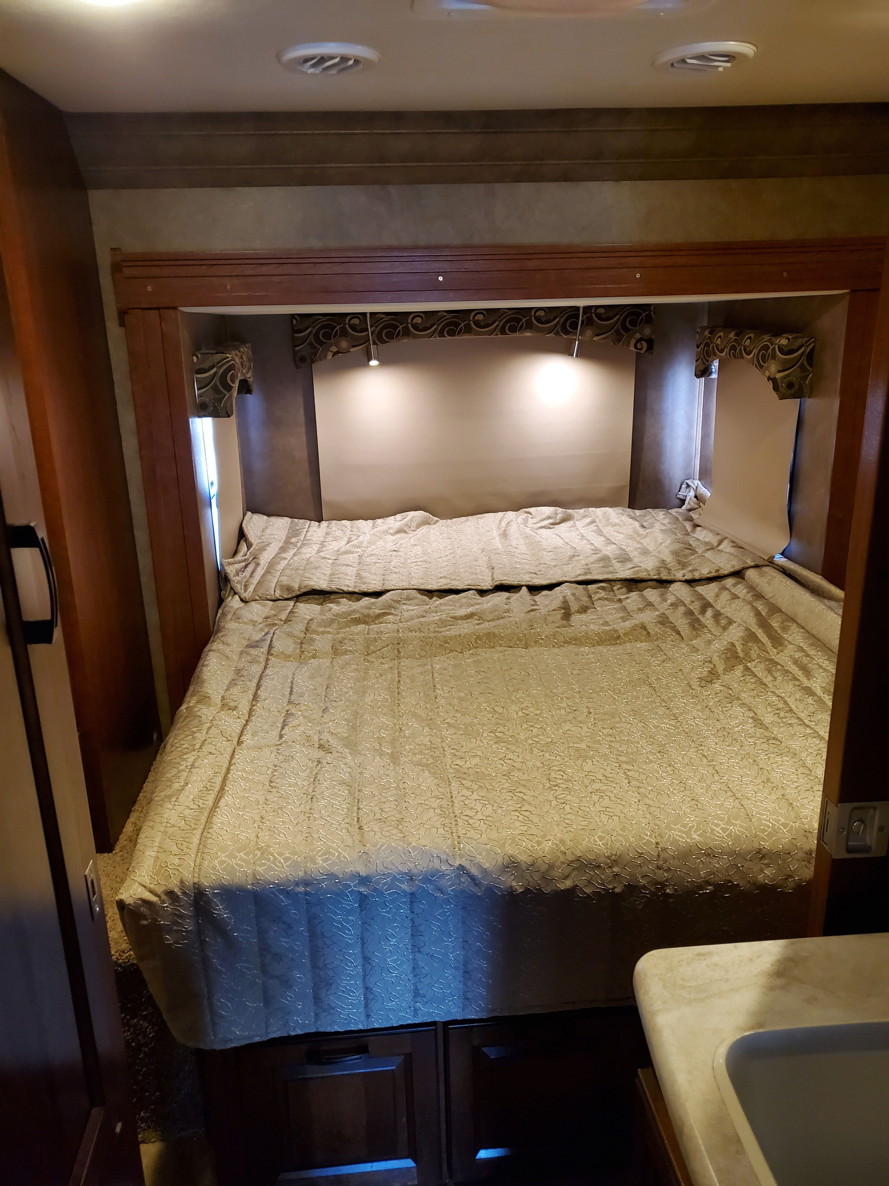 Cozy RV rental bedroom with a large bed, built-in reading lights, and compact storage. Perfect for a comfortable trip.. Forest River Sunseeker 2016