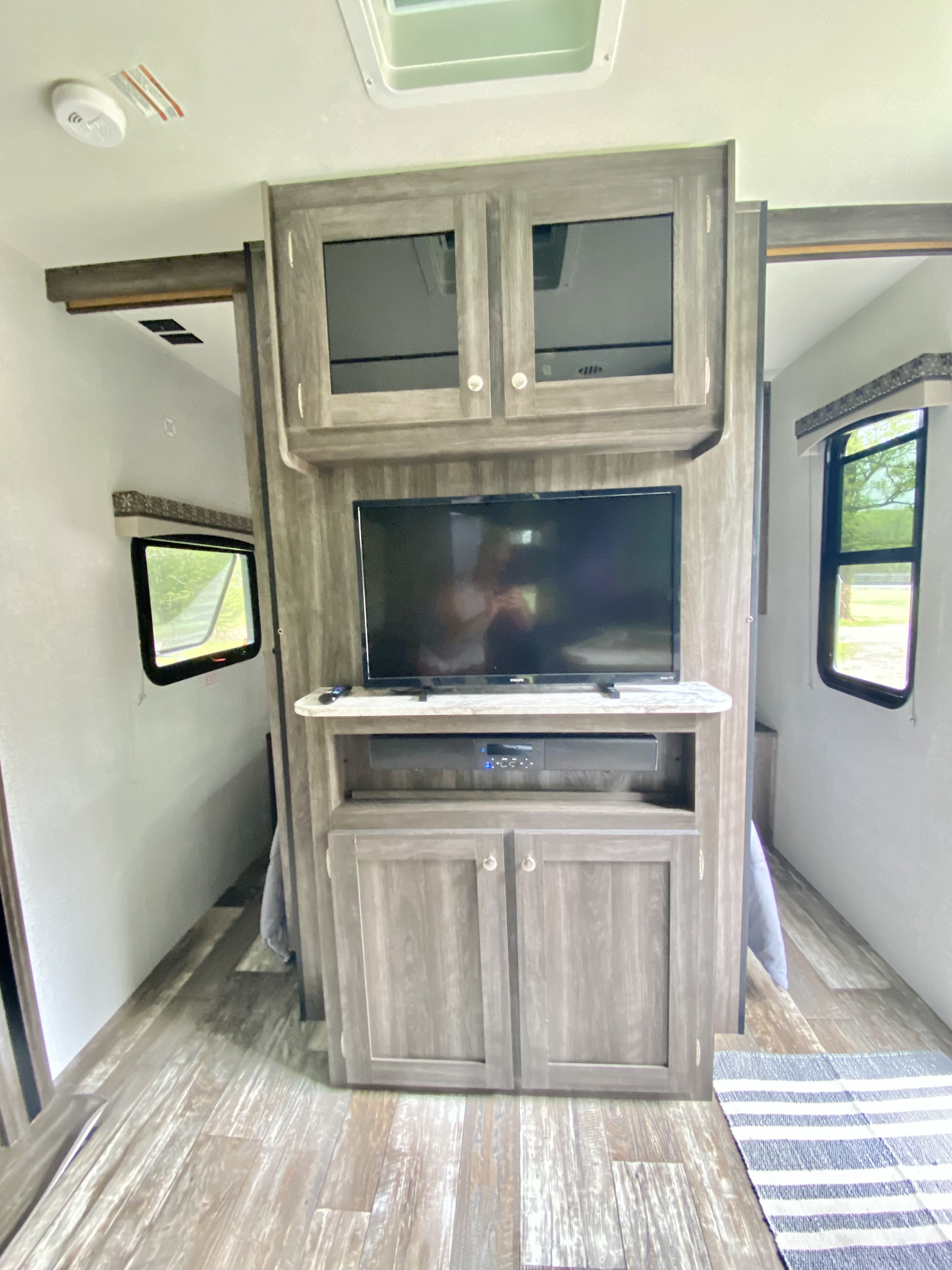 Inside a modern RV rental: central entertainment unit with TV, soundbar, and storage.. Starcraft Autumn Ridge Outfitter 2020