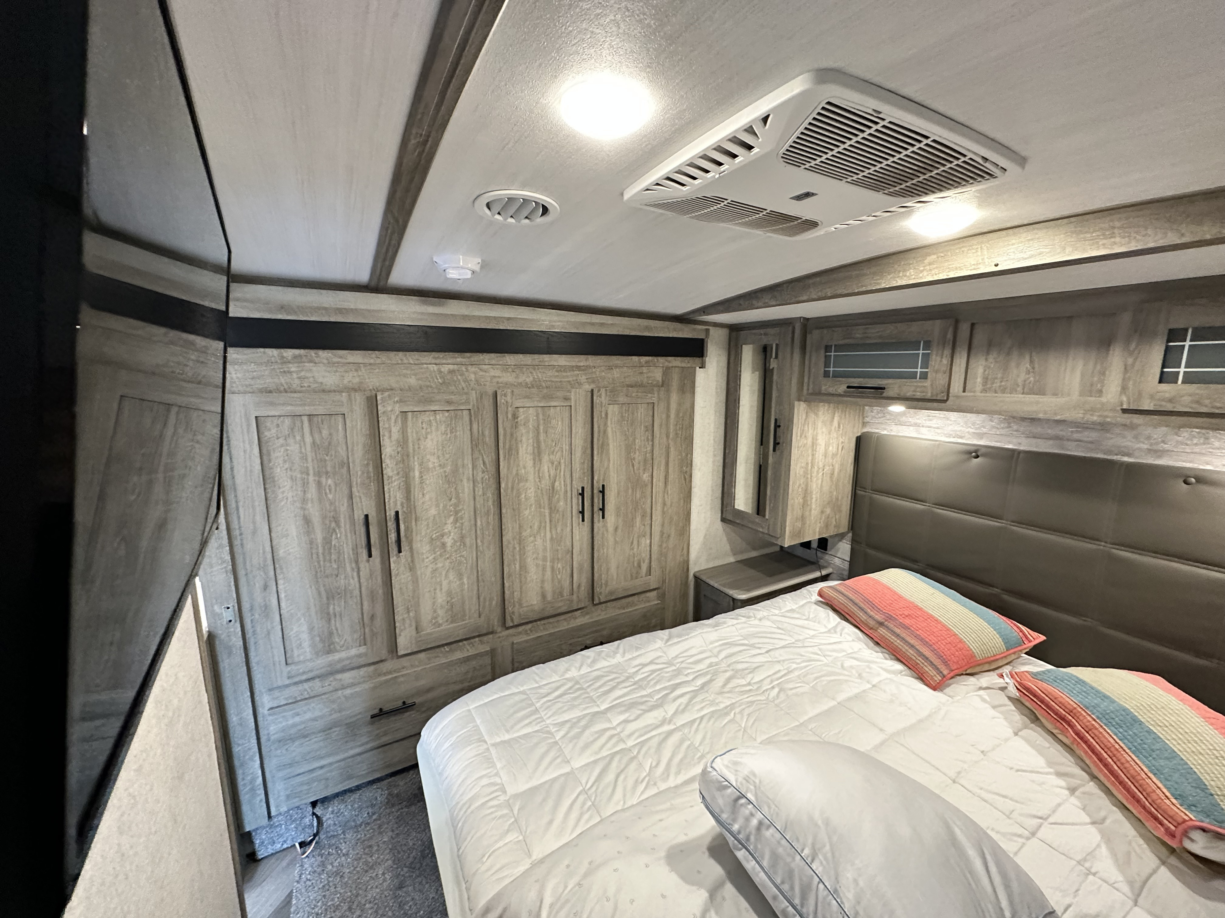 This comfortable RV rental bedroom features a large bed, full wardrobe, and modern amenities for a pleasant stay on the road.. Forest River Salem Hemisphere 2020