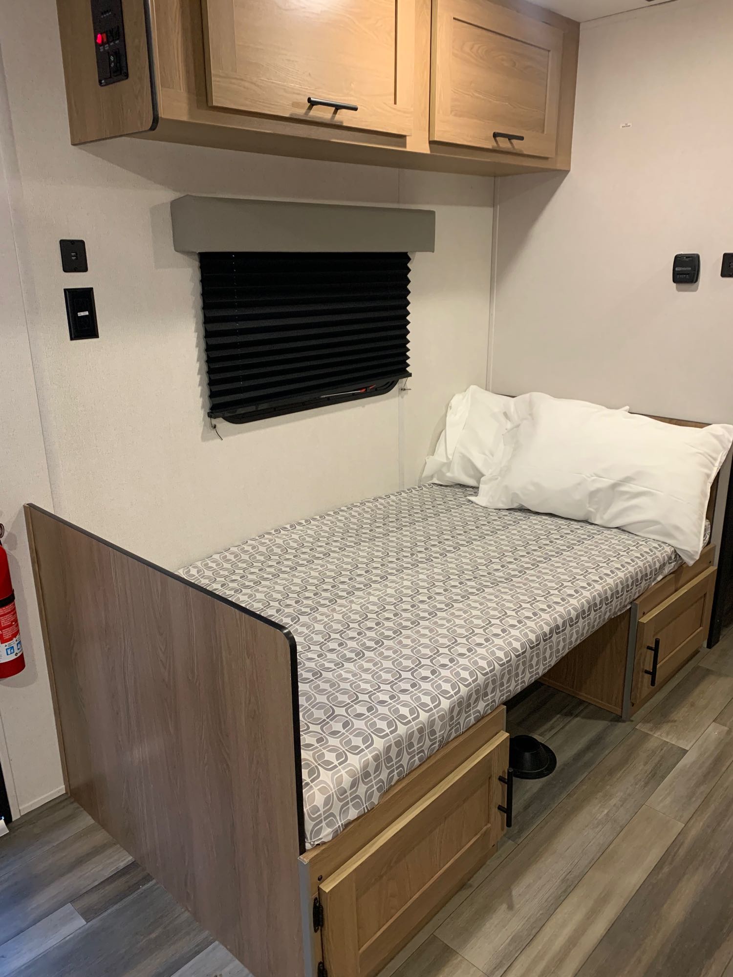 Cozy RV rental bed with storage, window, and overhead cabinets for a comfortable travel experience.. Forest River Other 2023