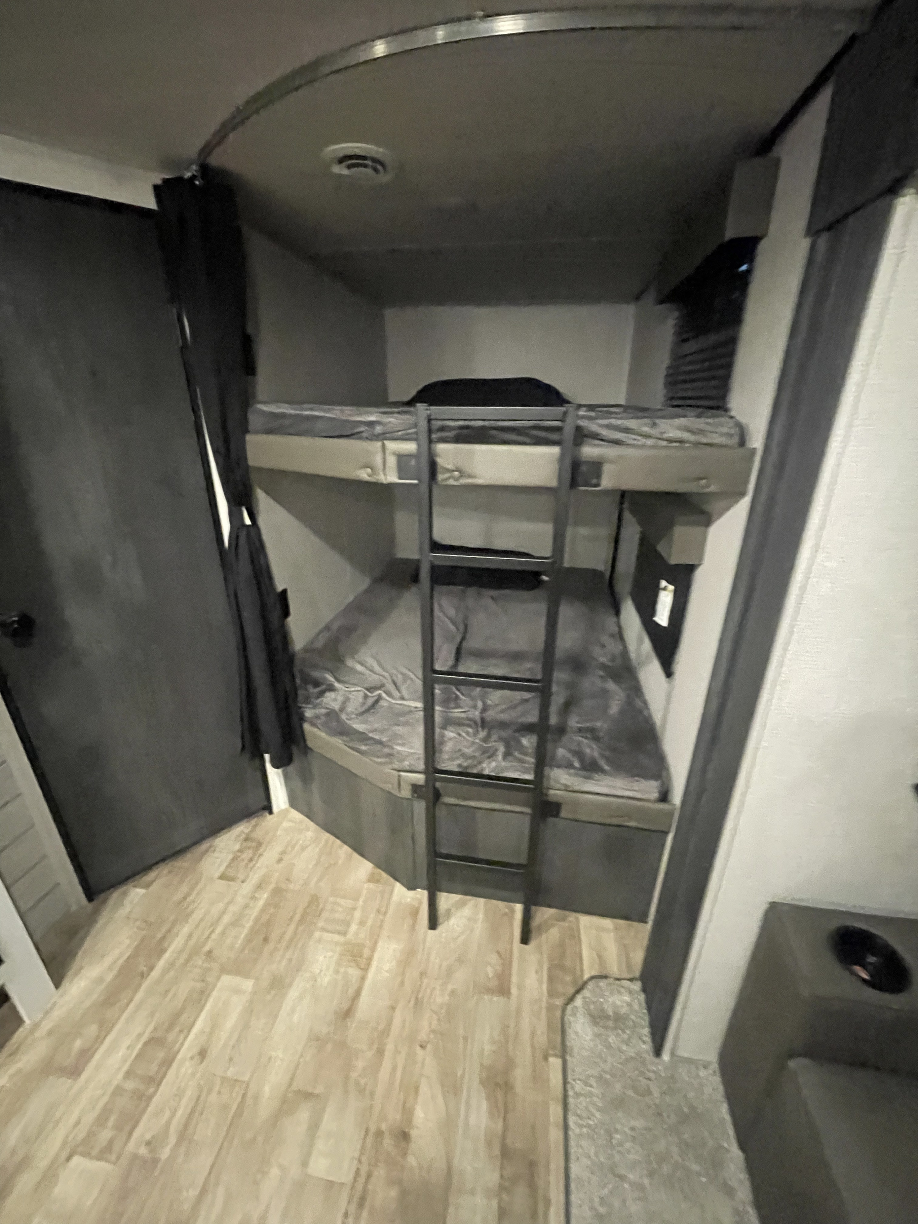 RV rental: Compact bunk beds with gray bedding, ladder, and light wood floor in a cozy interior.. Keystone RV Hideout 2022
