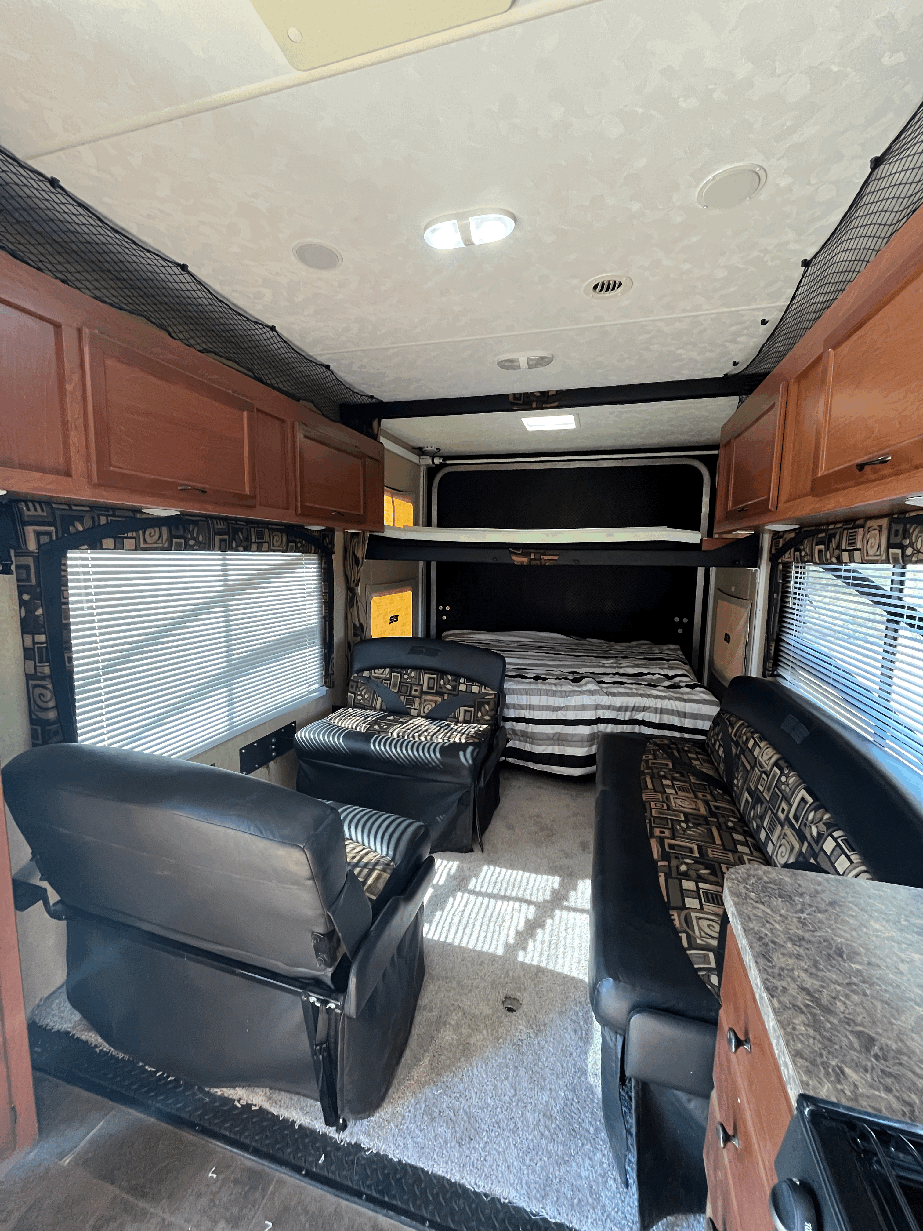 RV rental interior: A comfortable living space with a bed, versatile seating, and overhead storage.. Pacific Coachworks Sandsport 2013