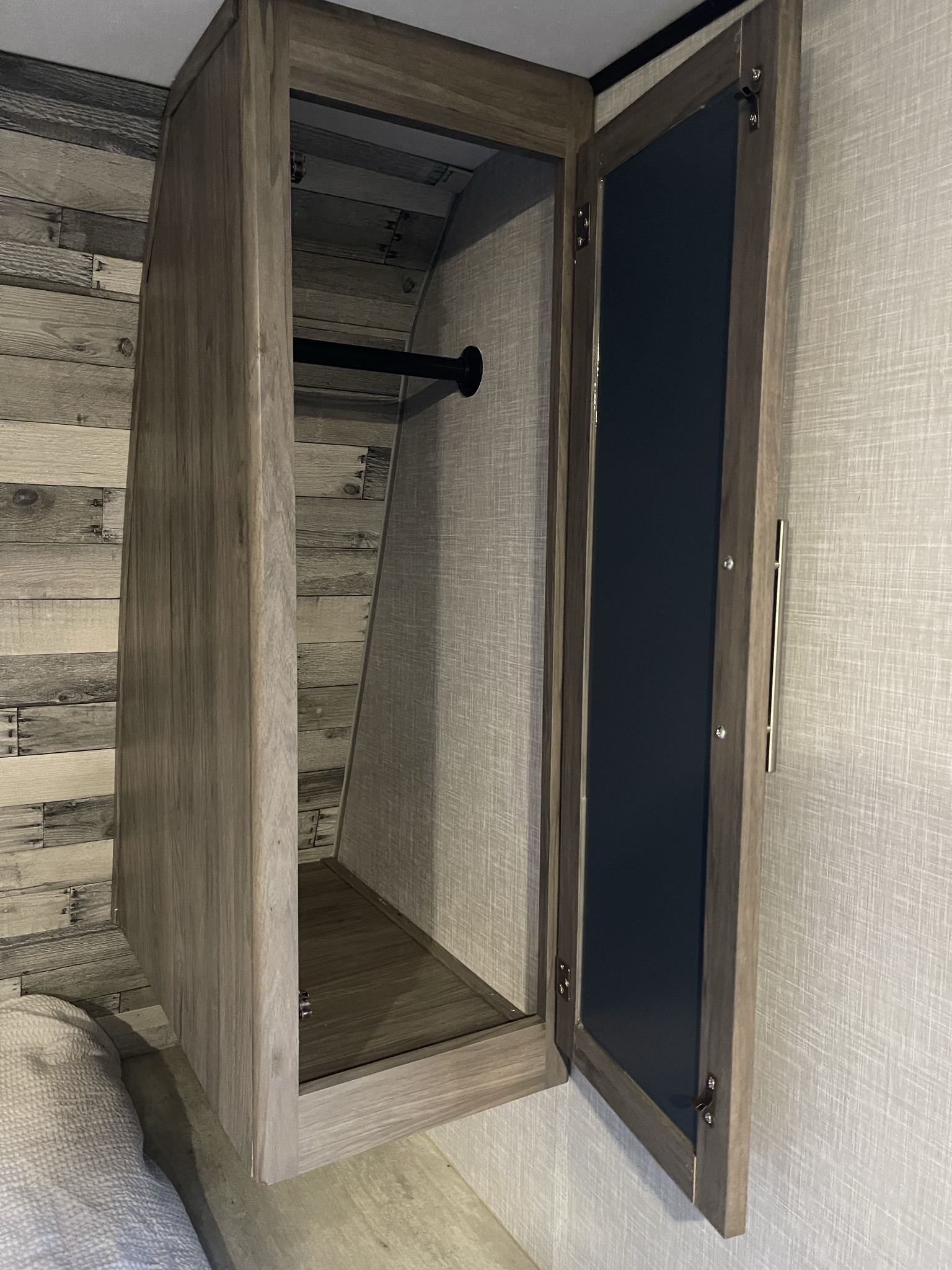 RV rental storage: An open wood closet with a hanging bar, showcasing compact interior design.. Crossroads RV Zinger Lite 2021