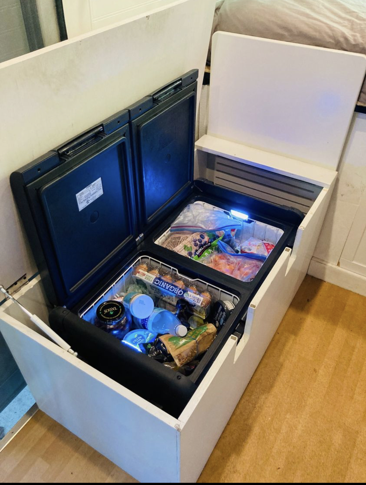 Compact living: Dual-zone fridge/freezer custom-built into an RV rental's storage, full of fresh and frozen food.. Dodge Other 2017