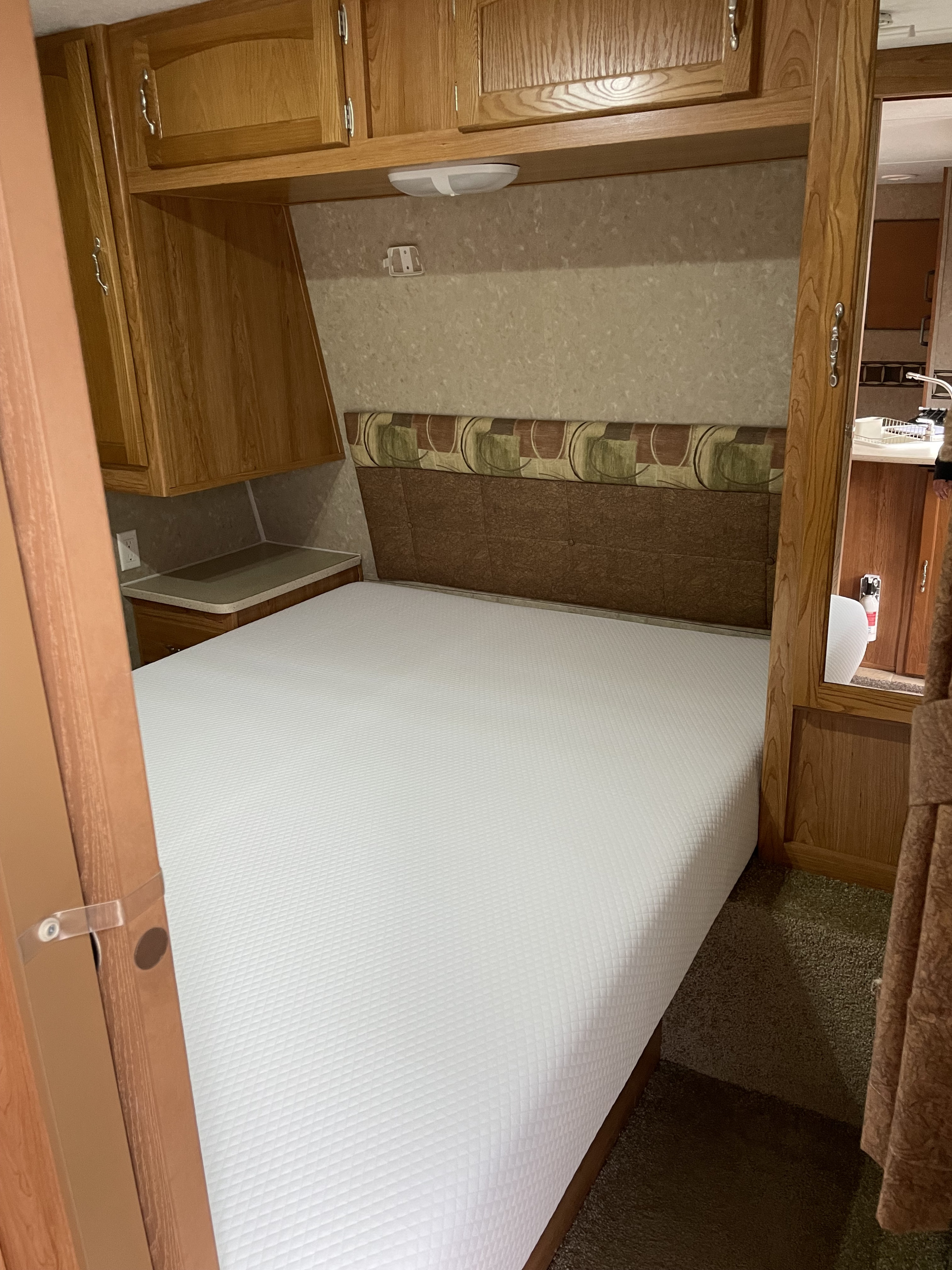Cozy RV rental bedroom with new mattress, cabinets, and headboard.. Puma 30DBSS 2009