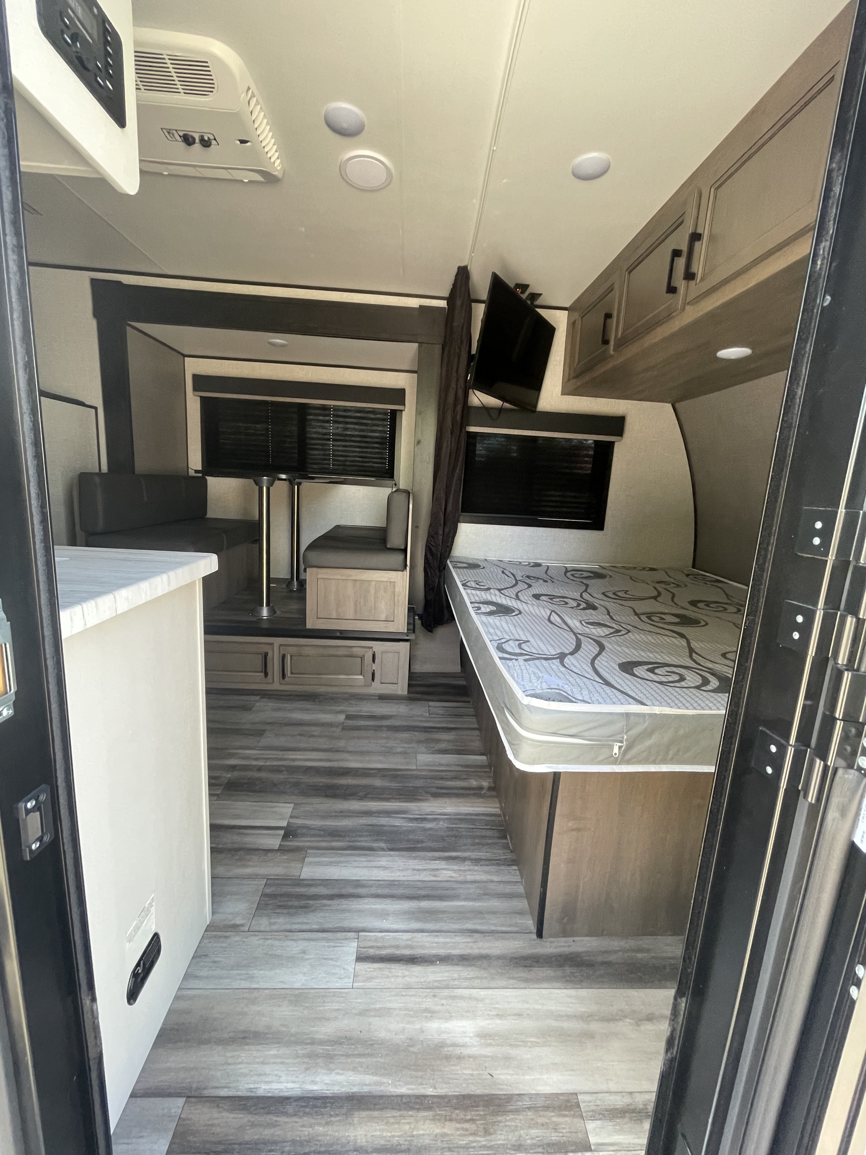 RV rental: View of a camper's interior from the entrance, showing a dinette, bed, and kitchen counter.. Highland Ridge Open Range 2023