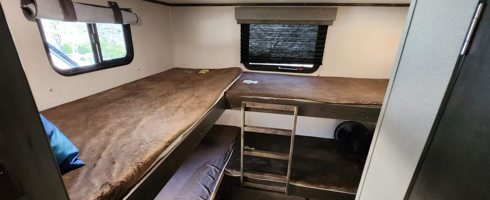 RV rental: Spacious camper interior with four bunk beds (two per side) and windows, ideal for family sleeping.. Grand Design Transcend 2020