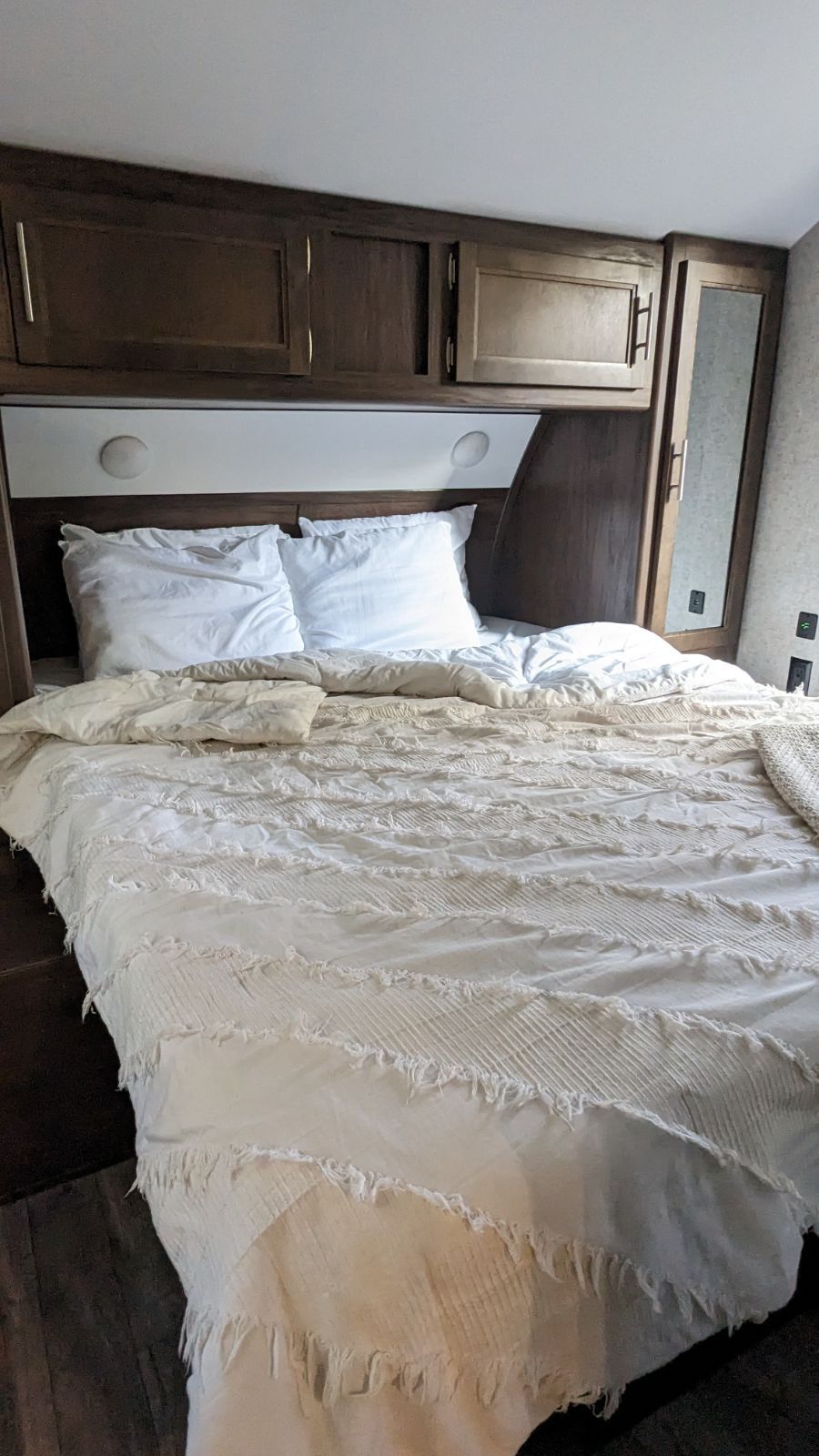 RV rental's inviting bedroom: built-in storage, a comfy bed, and textured bedding for a restful trip.. Forest River Cherokee Grey Wolf 2018