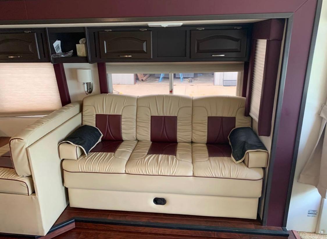 This comfortable cream & burgundy sofa in an RV rental offers a cozy living space for your next adventure.. Damon Intruder 1999