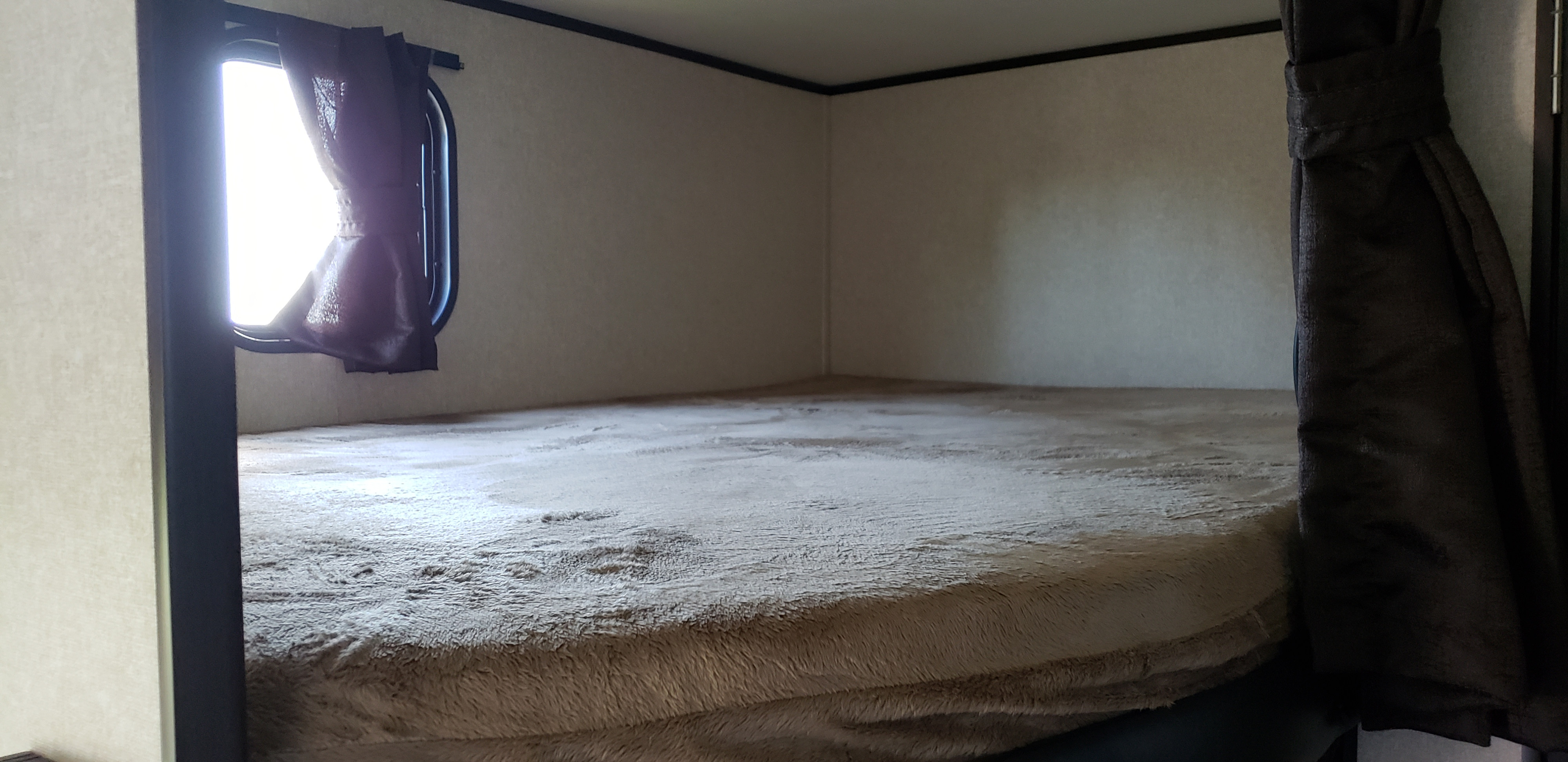Inside an RV rental: a cozy bunk bed with a bright window and soft, plush blanket.. Jayco Jay Flight SLX 2018
