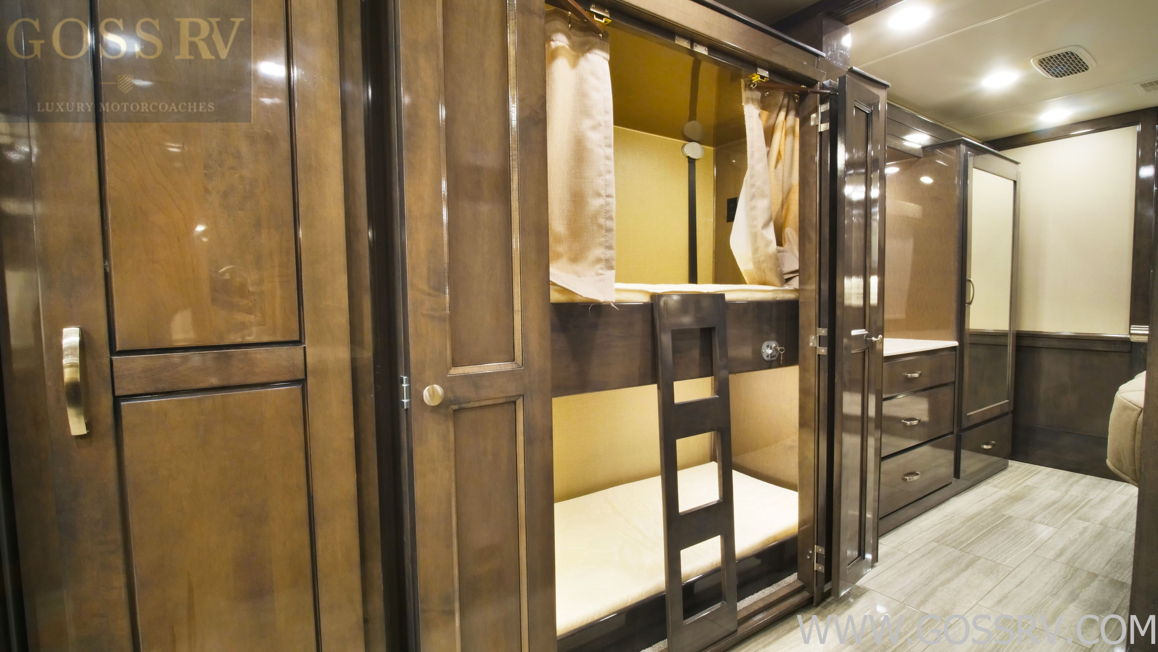 Luxury motorcoach RV rental interior showcasing private bunk beds with wood cabinetry and ladder, perfect for family comfort.. Entegra Coach Reatta 2021
