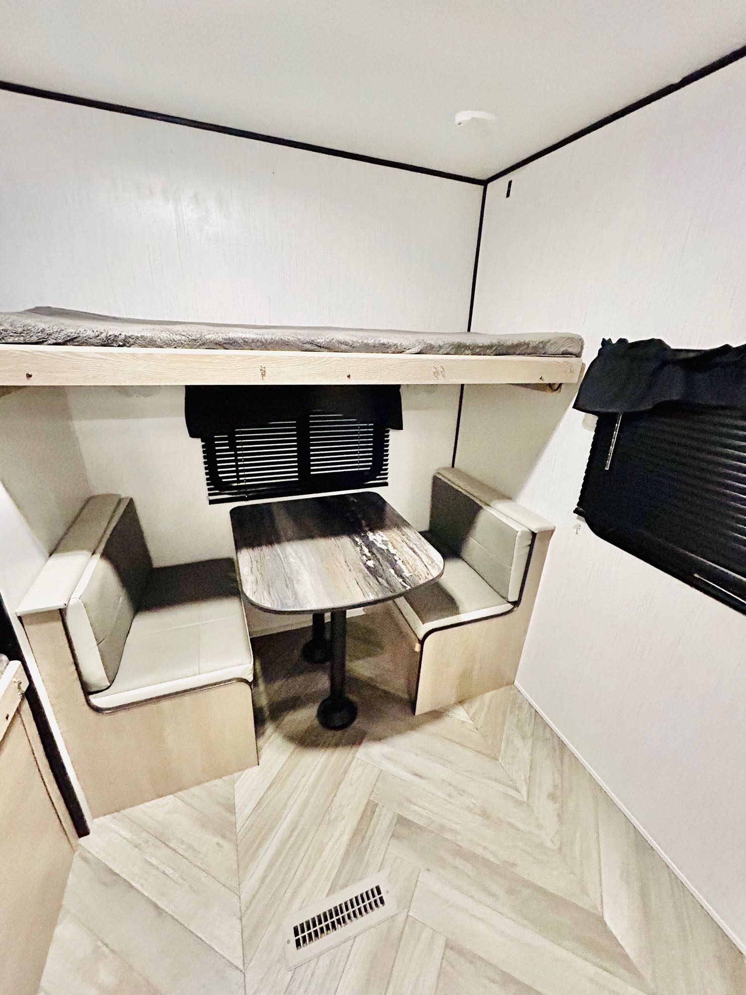 Cozy RV rental interior with a bunk bed, dinette, and modern herringbone flooring.. Heartland 303BH 2022