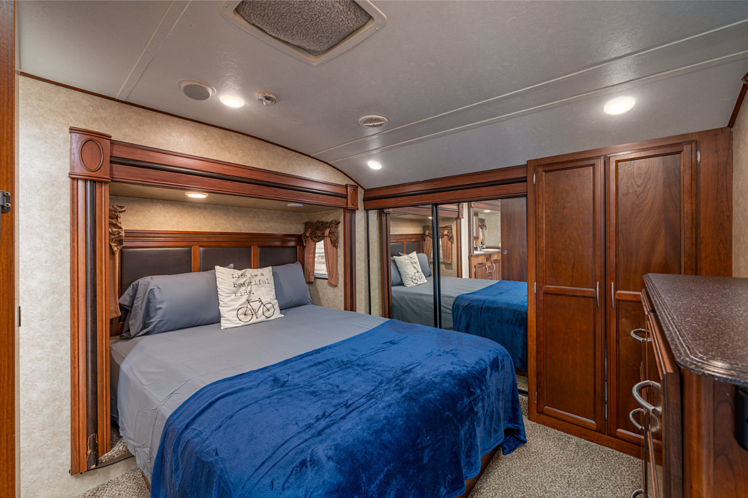 Experience comfort in this RV rental bedroom featuring a queen bed, mirrored closet, and wood storage.. Crusader Crusader Fifth Wheel 2014