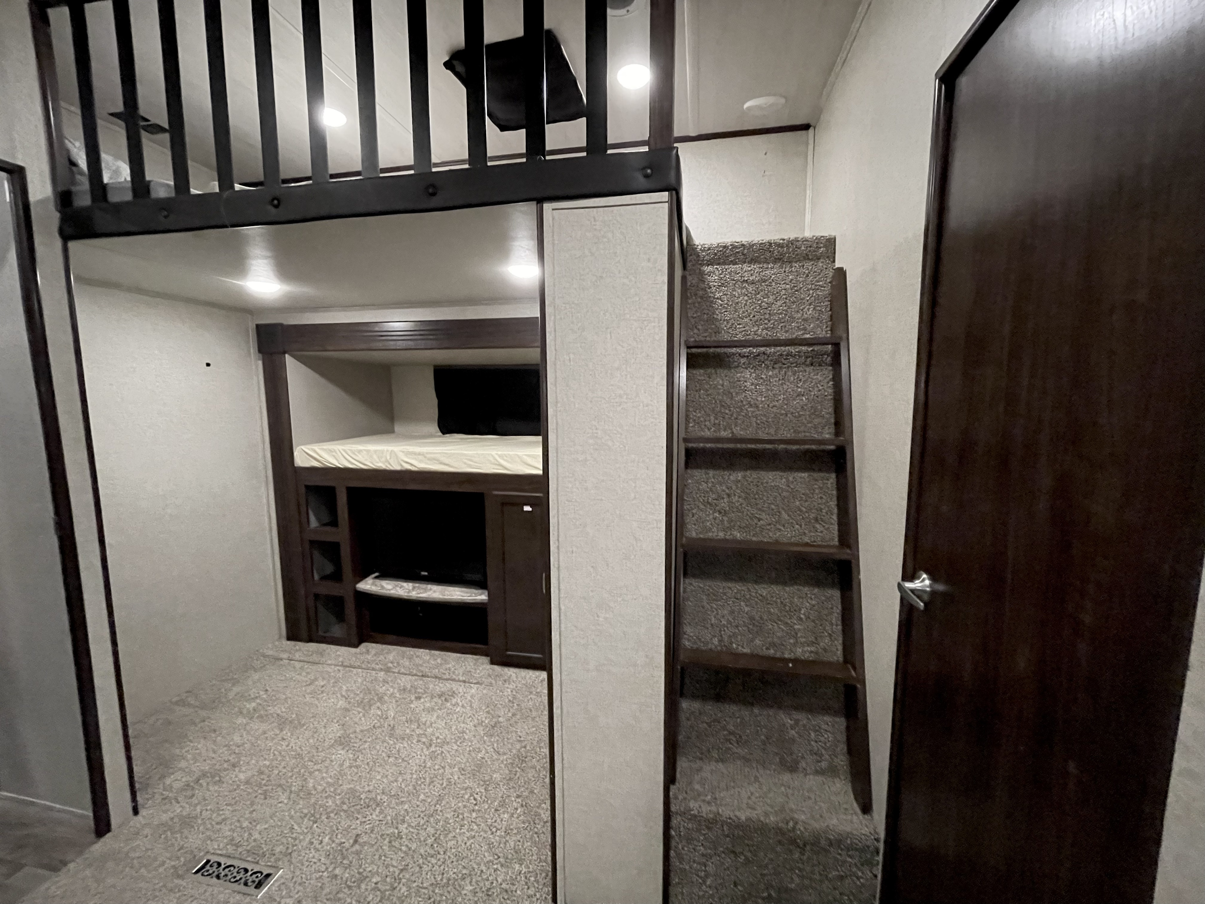 RV rental interior: a comfortable sleeping loft with ladder access, lower bunk bed, and TV area.. Heartland RVs Sundance 2016