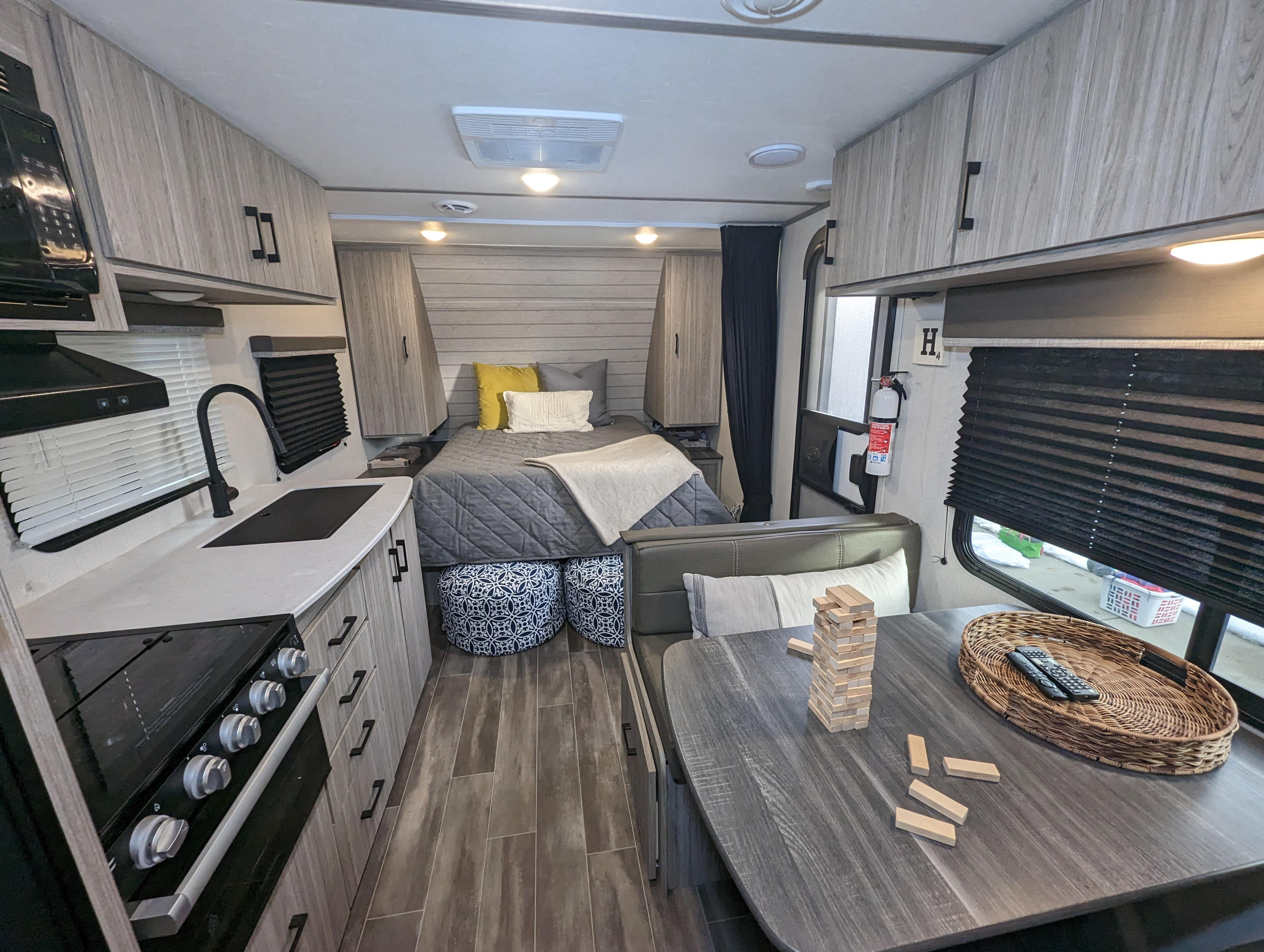 Modern RV rental interior showing a kitchen, bed, and dining area with games, providing a cozy living space.. Keystone RV Passport SL 2021