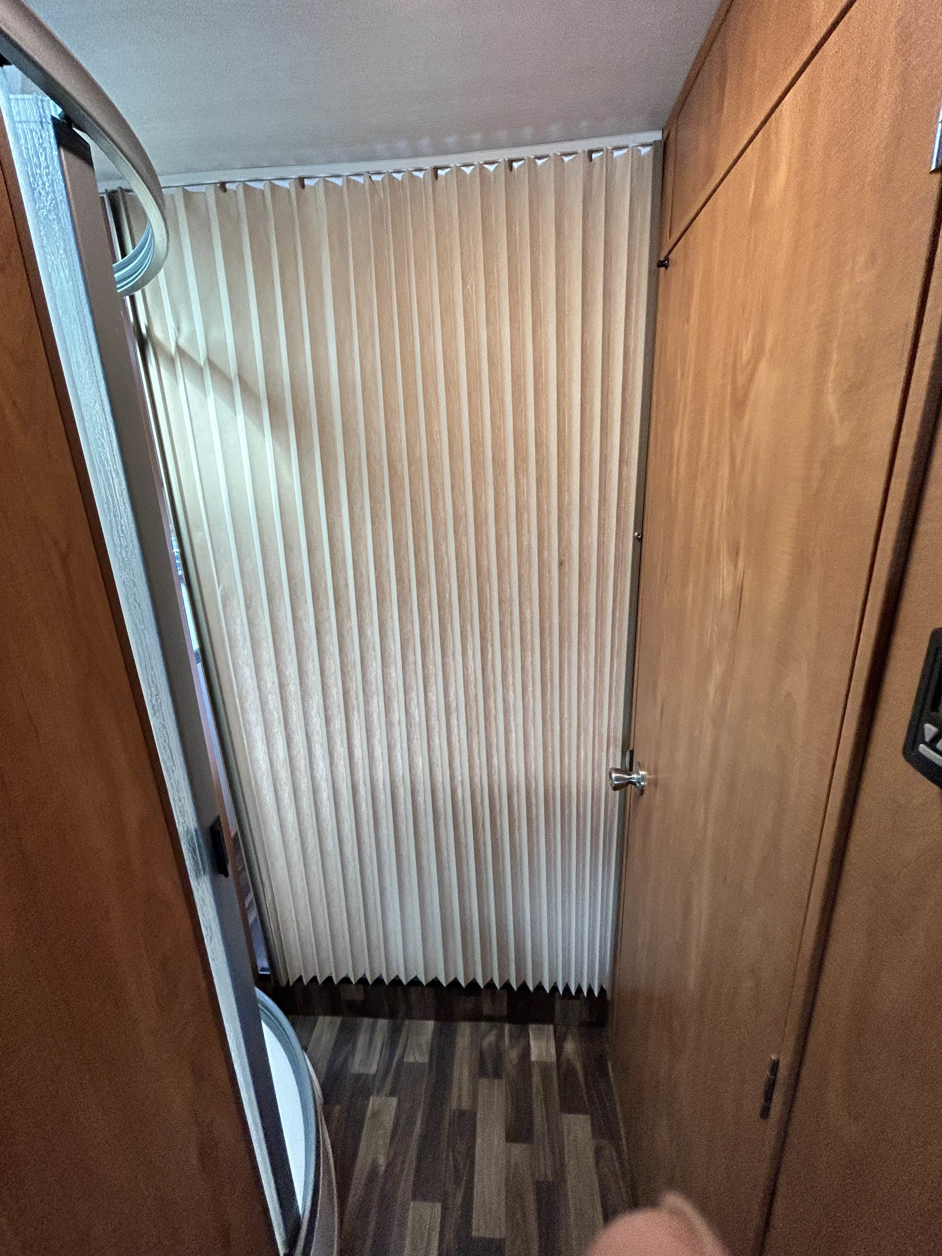 RV rental interior: narrow hallway with wood walls, pleated blinds, and wood-look flooring.. Nexus Phantom 2019