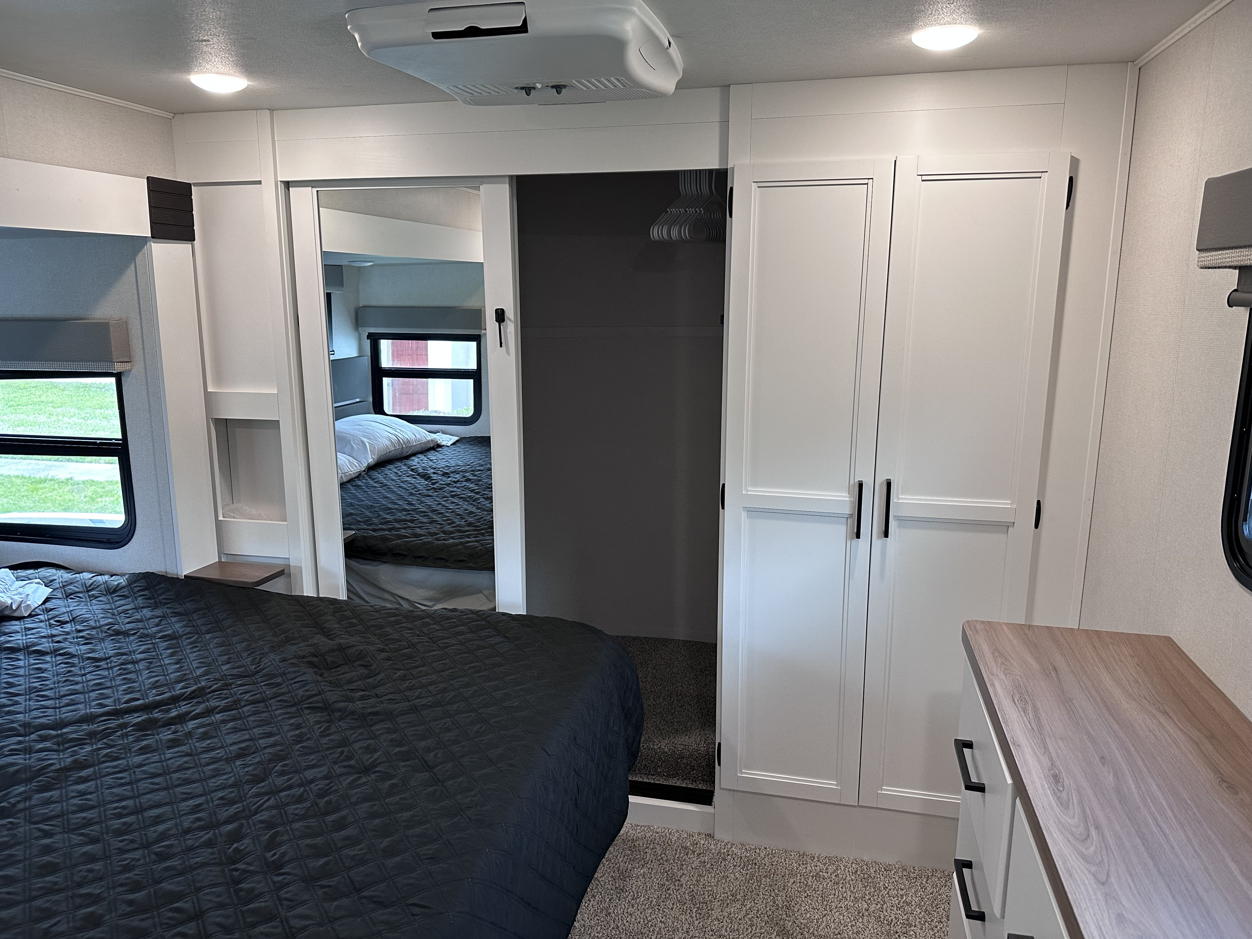 Spacious RV rental bedroom with a comfy bed, sleek sliding door, closet, and dresser, showcasing modern interior design.. Crusader Crusader Fifth Wheel 2022