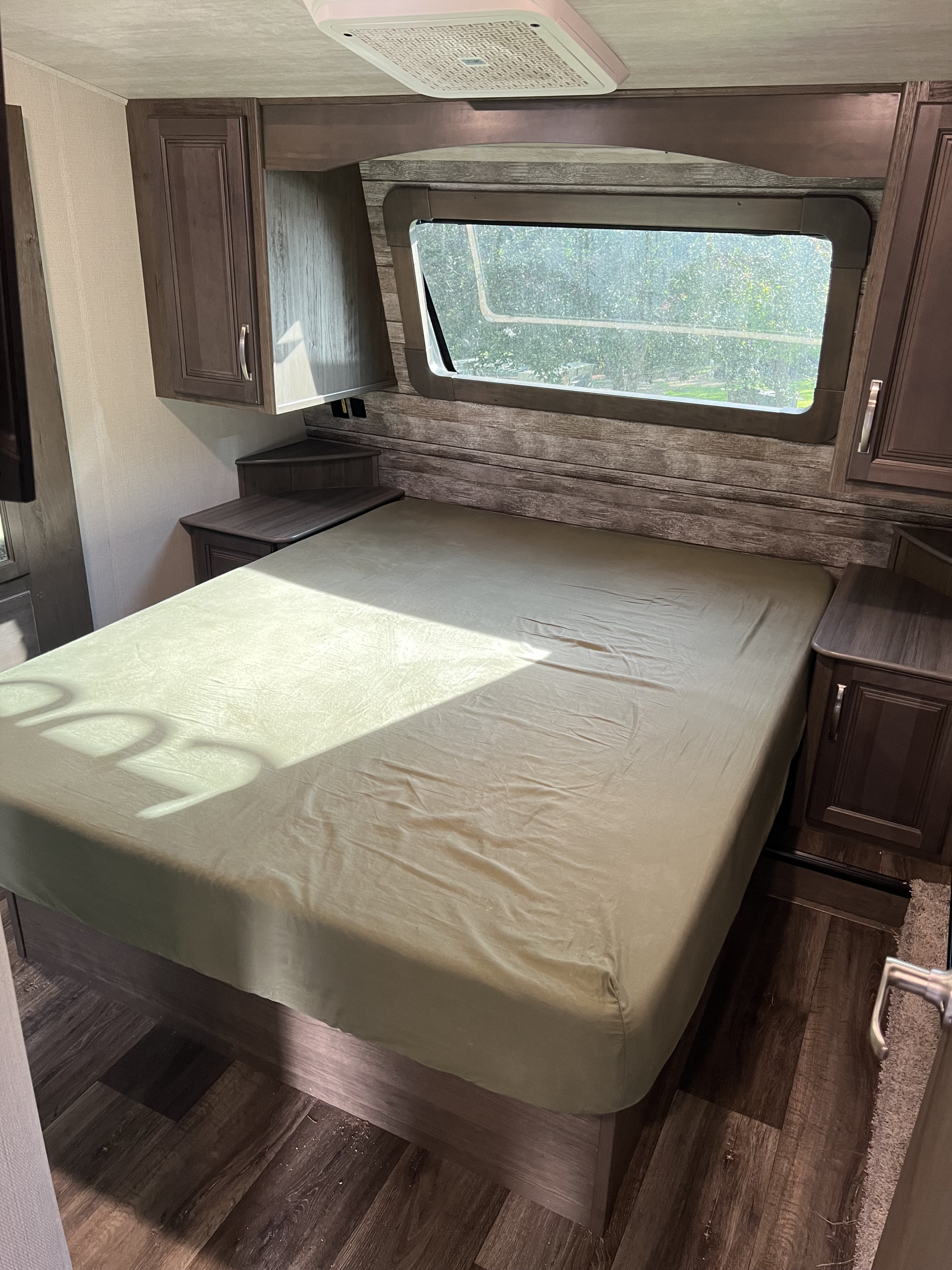 Inside an RV rental bedroom: cozy bed, built-in storage, and a large window for scenic views.. Keystone RV Cougar 364 BHL 2022