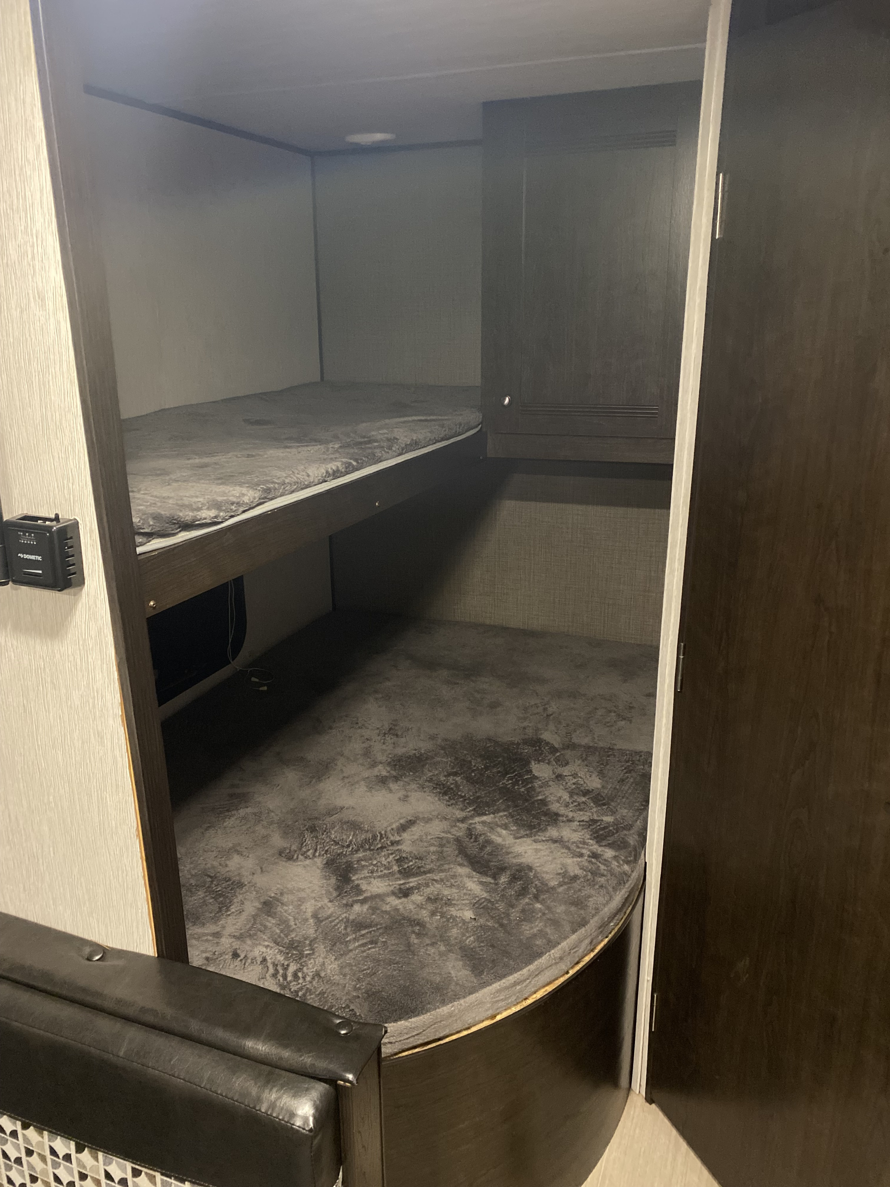 This RV rental features cozy bunk beds with soft grey mattresses, providing comfortable sleeping space.. Heartland RVs Prowler 2021