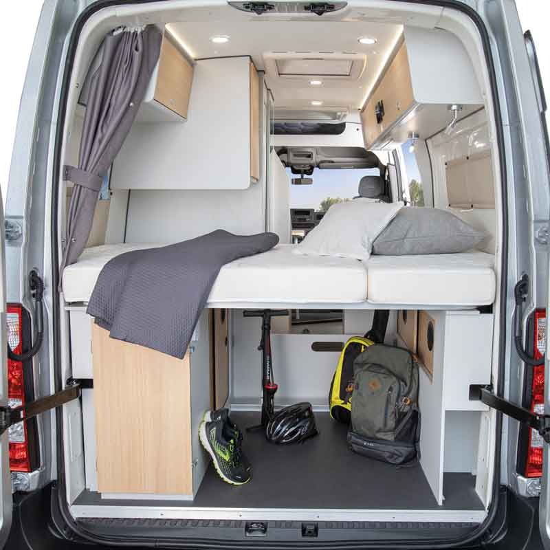 Inside this RV rental: a cozy camper van bedroom with elevated bed and convenient storage for gear, perfect for adventure.. fontvendome mastervan 2023