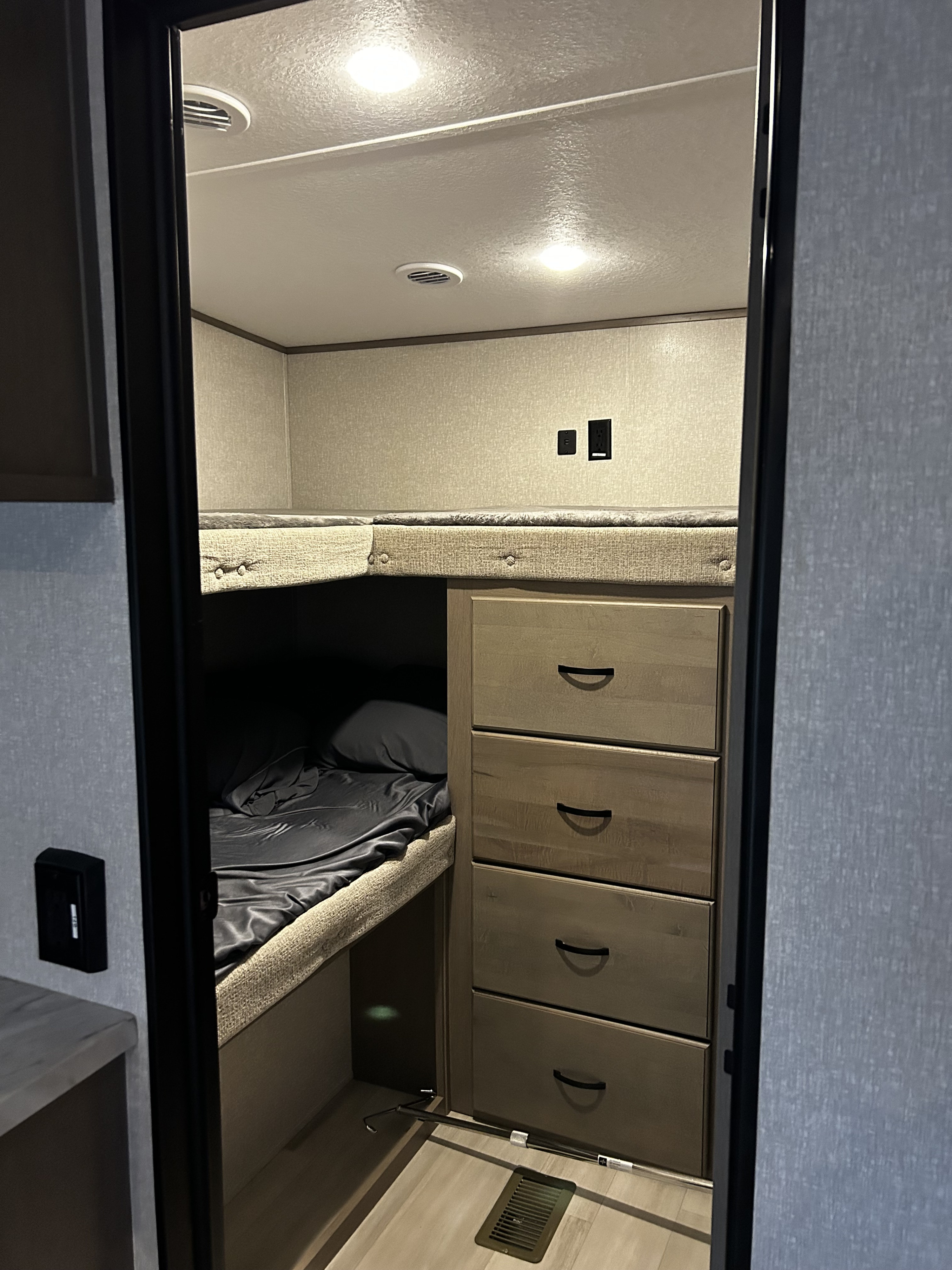 RV rental bunkhouse: offering upper and lower bunks, integrated storage drawers, and overhead lighting for travelers.. Coachmen Chaparral 2022