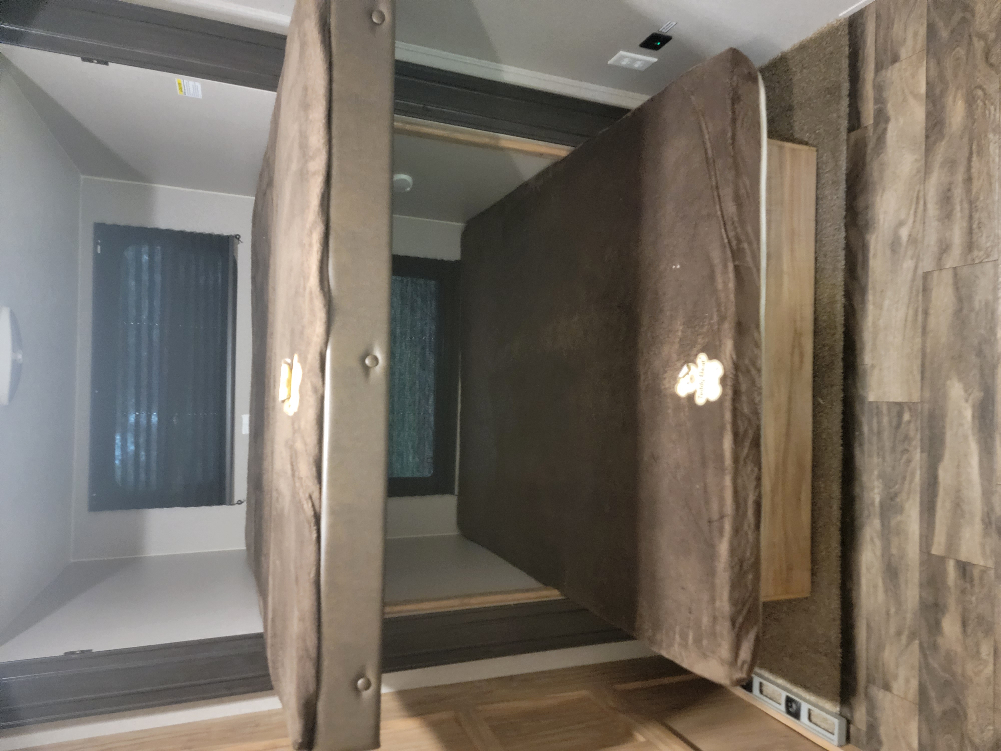 RV rental interior: a versatile bedroom with one brown mattress lifted to show storage or a lower bunk, ideal for travel.. Coachmen Freedom Express 323bhds 2019