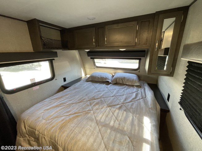 Cozy RV rental bedroom with a queen bed, overhead cabinets, bedside shelves, and windows including emergency exits.. Jayco Jay Flight 2020