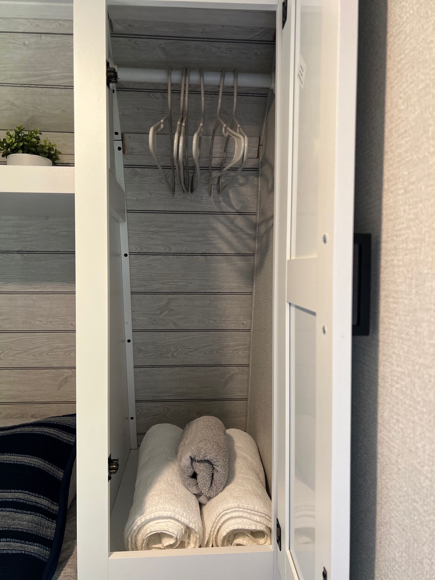 Inside your RV rental: a neat closet with hangers for clothes and soft, rolled towels for comfort.. Keystone RV Hideout 2023