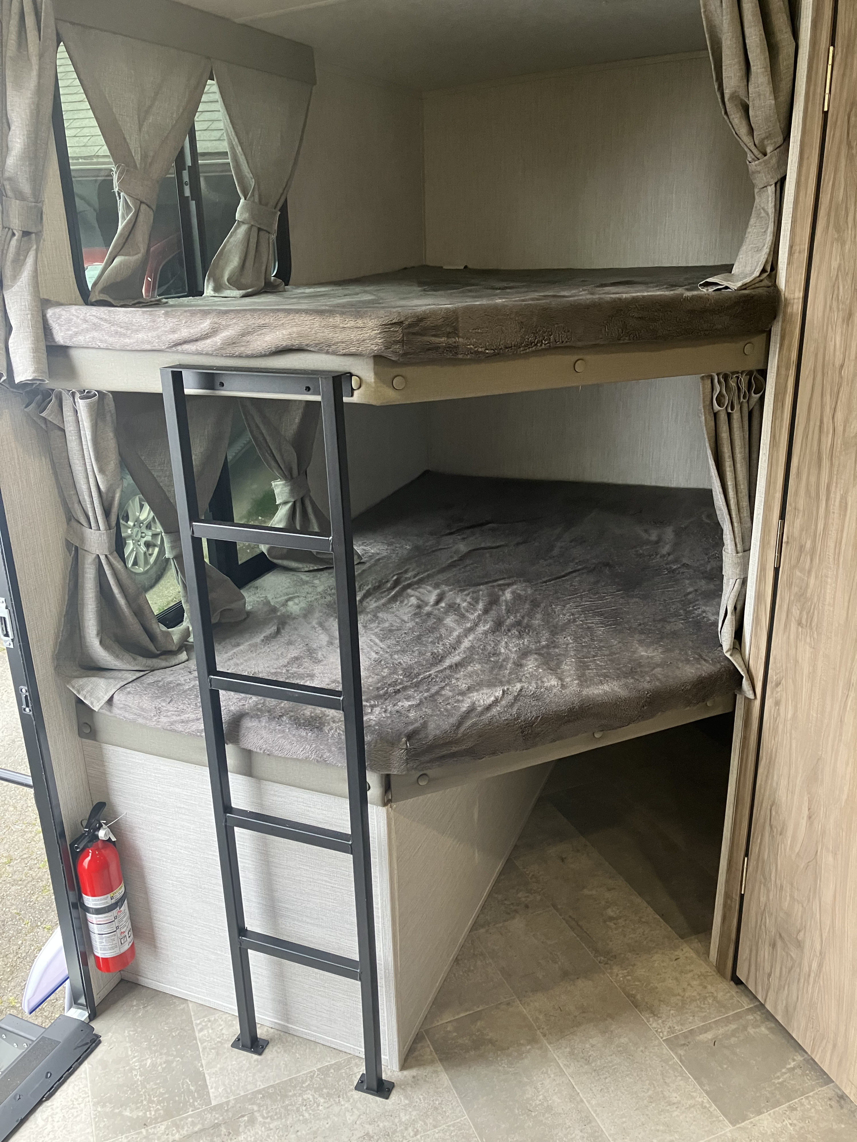 RV rental interior with cozy bunk beds, ladder, and a fire extinguisher. Ideal for family camping.. Forest River Palomino Solaire 2022