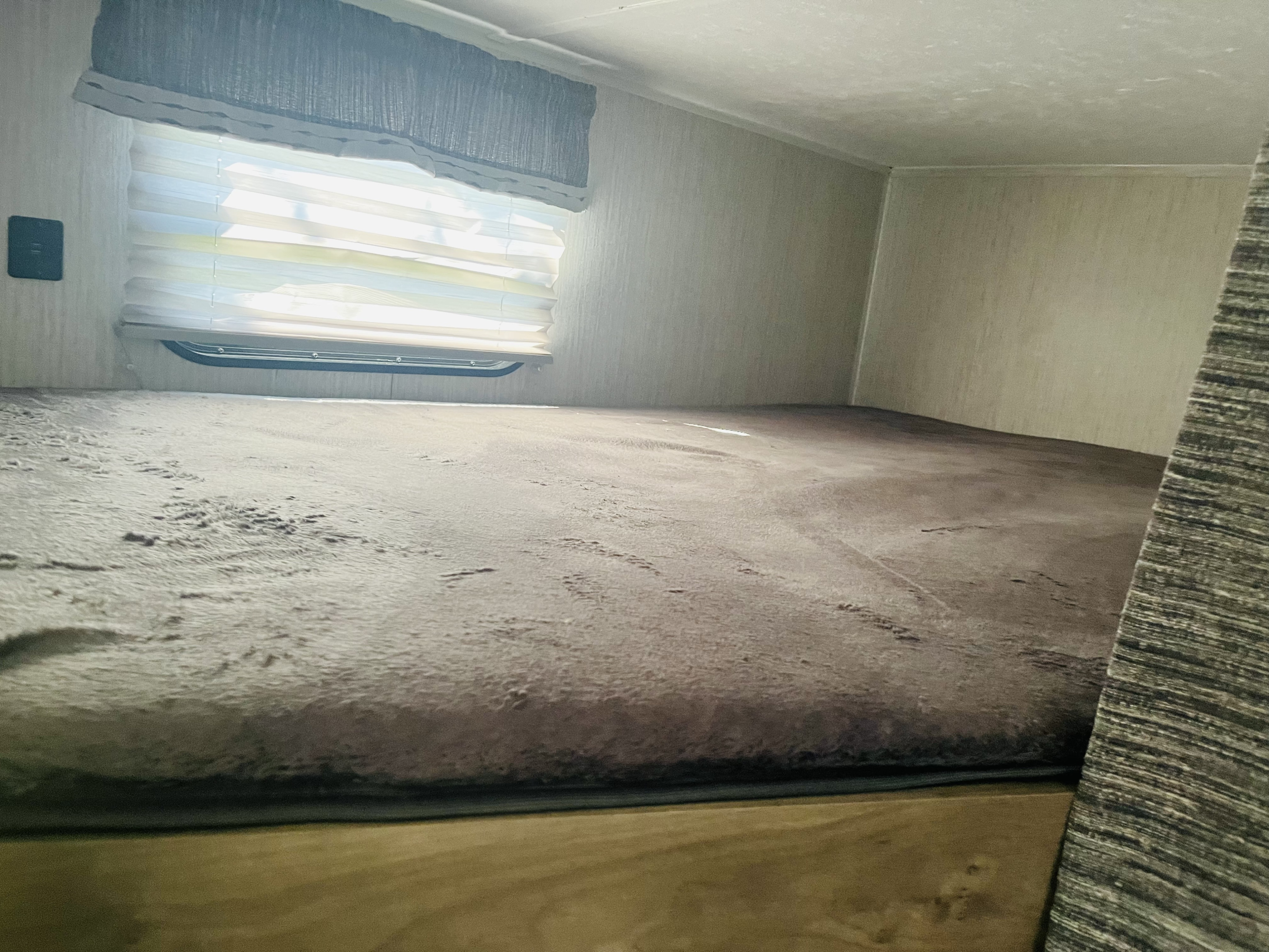 RV rental: View of a soft, grey bunk bed and window with blinds in a cozy camper sleeping area.. Palomino PUMA 22RBC 2022