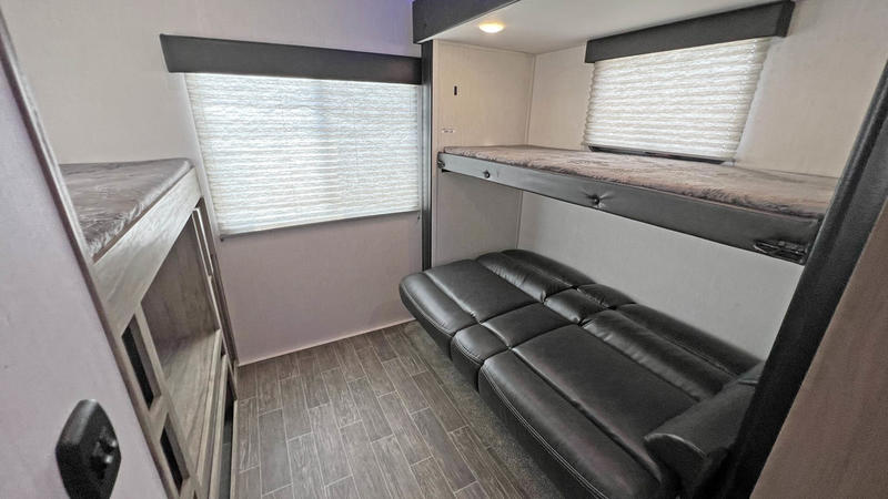 Versatile RV rental interior with bunk beds and a comfortable sofa, perfect for family adventures.. Forest River Cherokee Arctic Wolf 2022