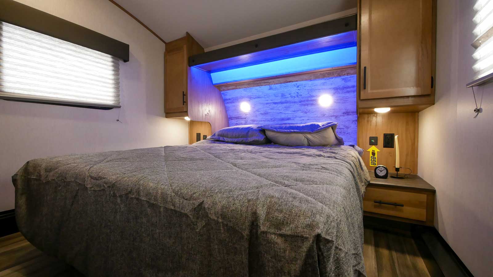 This inviting **rv rental** bedroom boasts a large bed, serene blue LED lighting, and convenient bedside power options.. Forest River Cherokee Arctic Wolf 2022