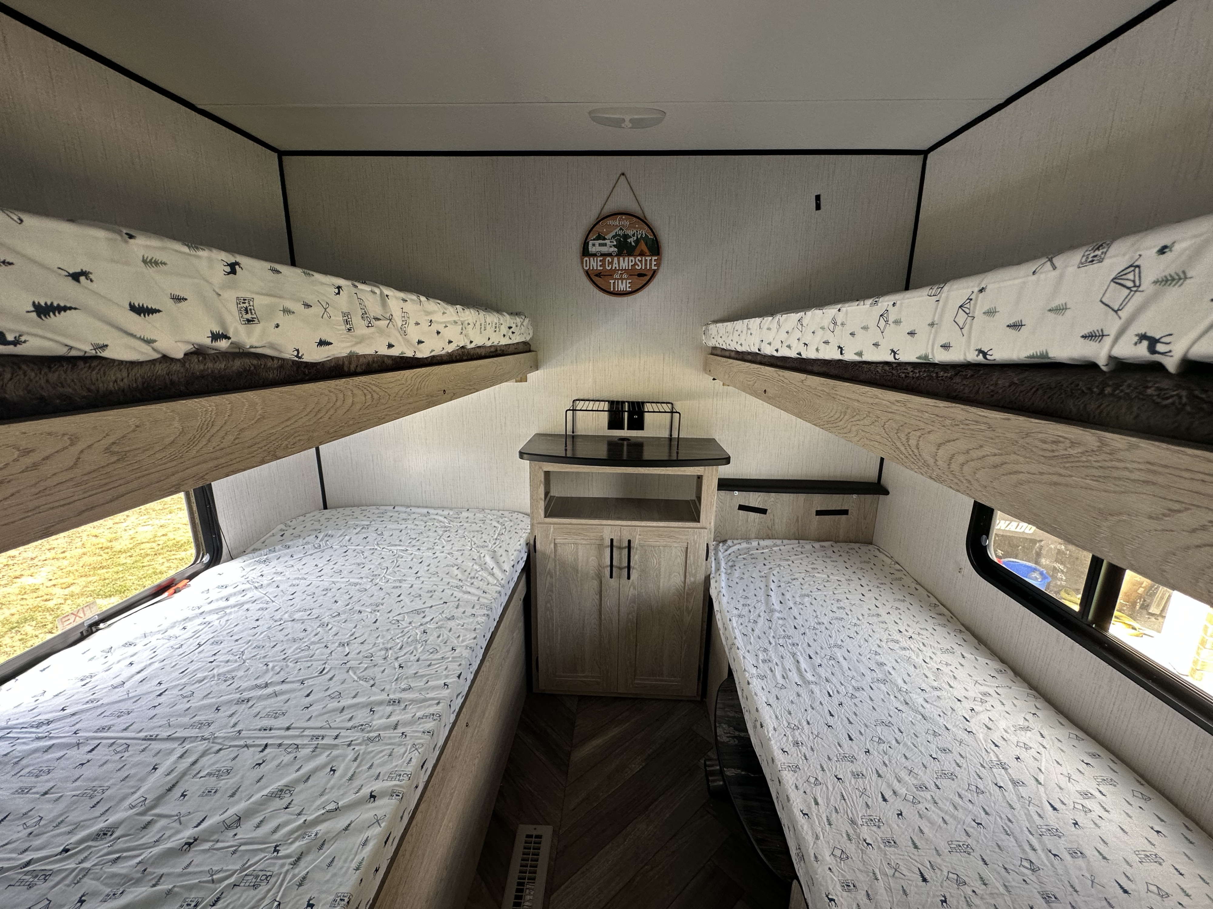 Roomy rv rental interior featuring four bunk beds with themed linens and a central cabinet, great for families.. Heartland RVs Prowler 2022