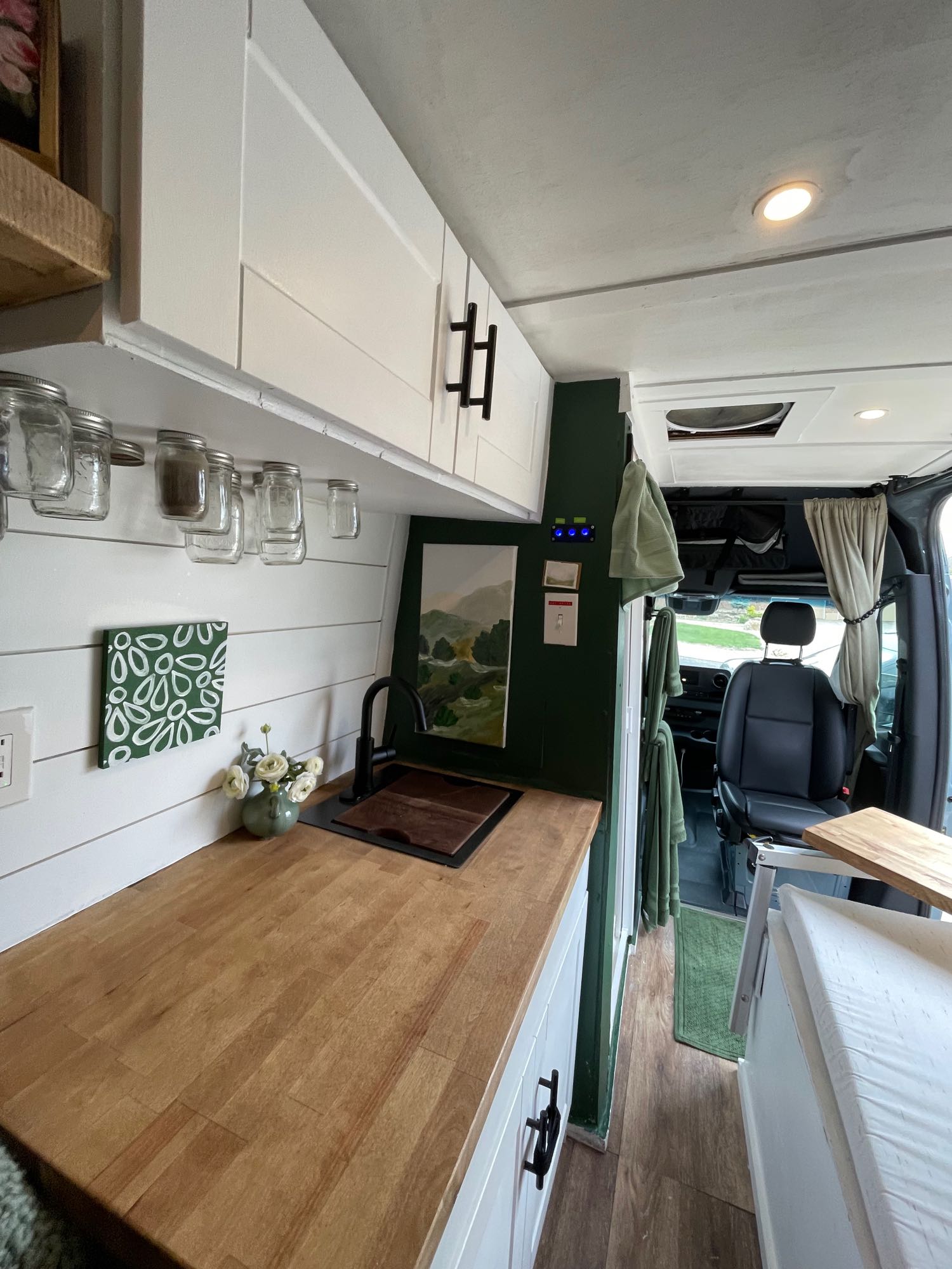 This custom rv rental camper van interior boasts a charming kitchen with wooden counters and cozy living space.. Mercedes-Benz Sprinter 2021
