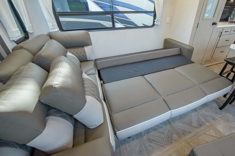 RV rental: A grey and white sectional sofa, partially converted into a bed, maximizes space in this modern RV interior.. Forest River Salem 2023